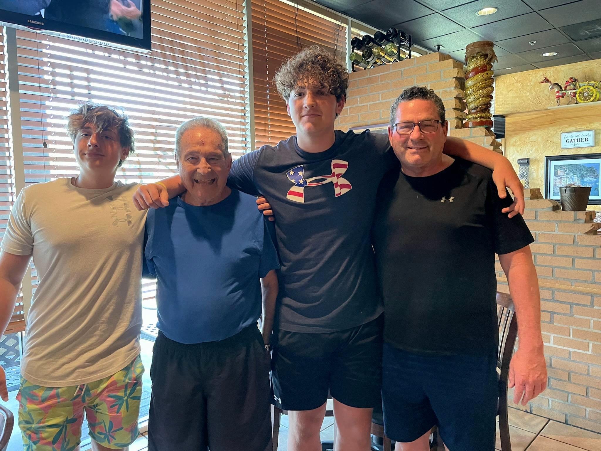 Four family members celebrate together in a casual eatery enjoying quality time and smiles.