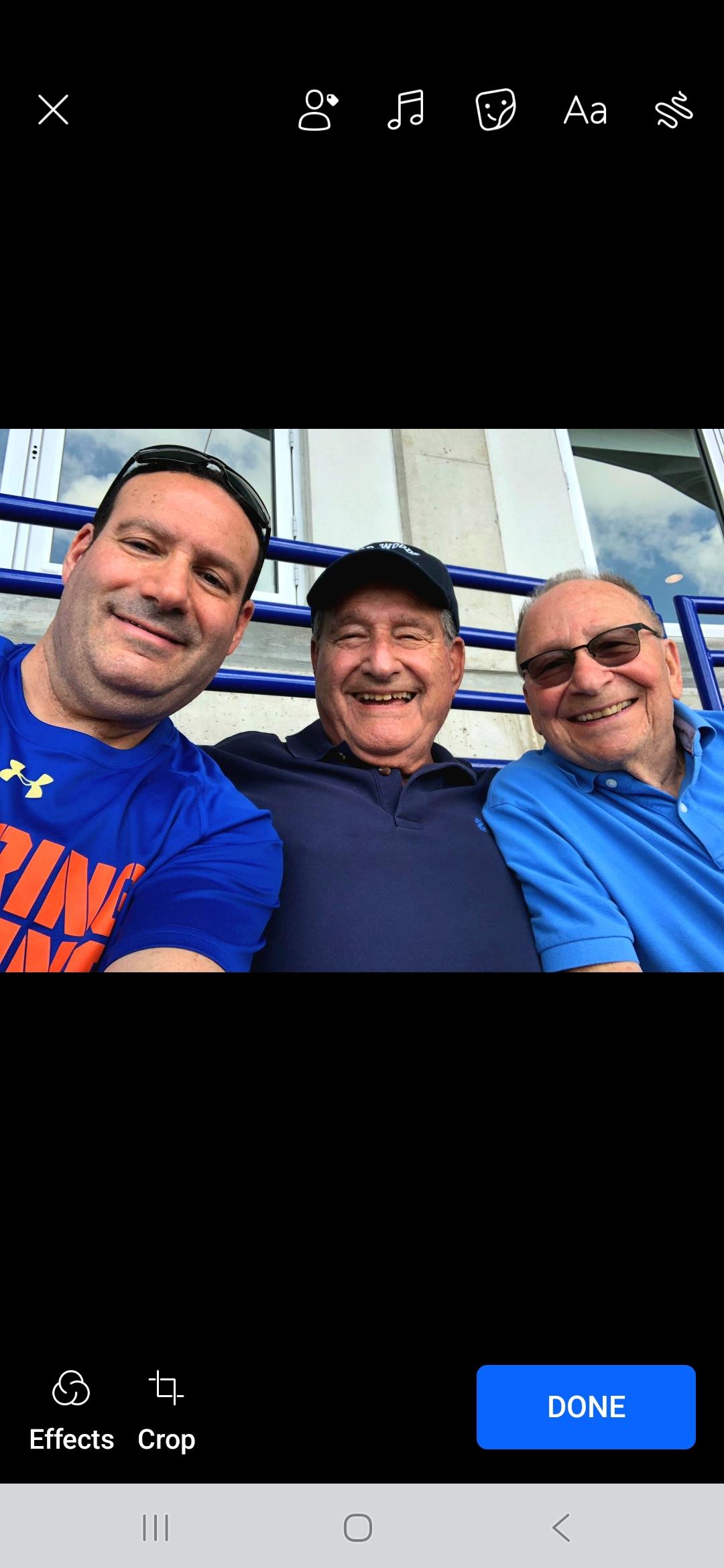Three friends smile and pose together in the stadium, excited for the game ahead.