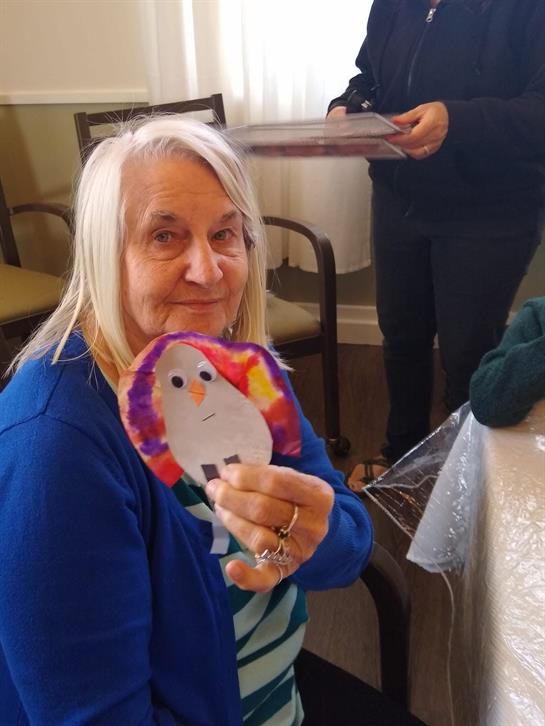 A woman holding a paper penguin