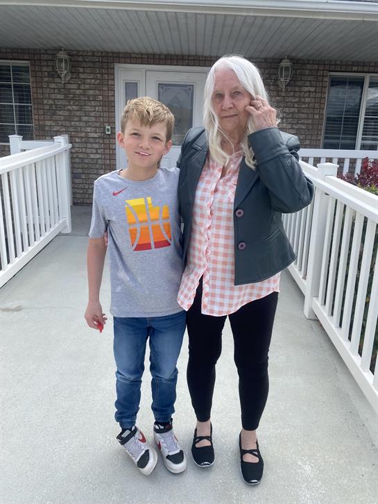 A woman and boy standing on a porch