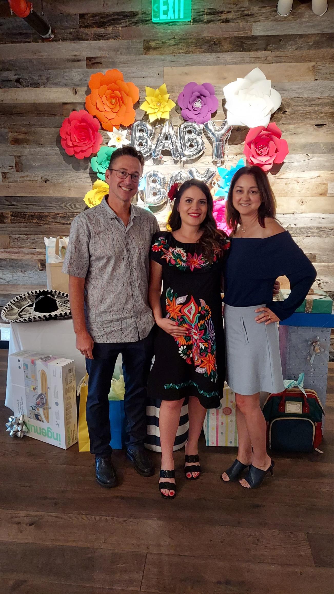 Guests gather for a festive baby shower, enjoying vibrant decorations and cheerful company.