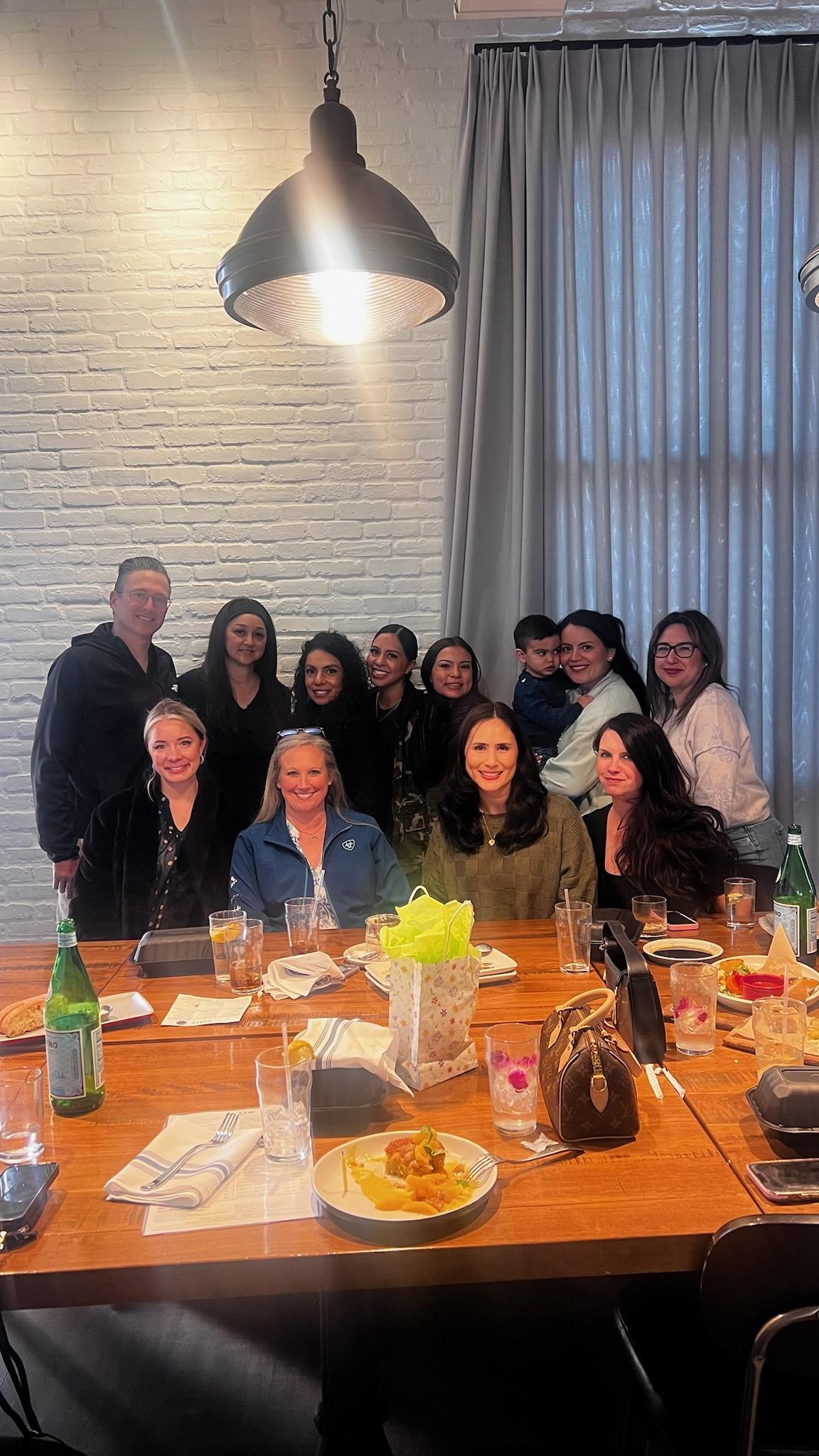 A group of friends enjoys a lively reunion dinner in a warm, inviting restaurant setting.