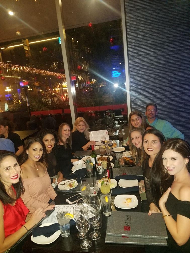 Friends gather at a vibrant restaurant, sharing food and drinks while enjoying each other's company.