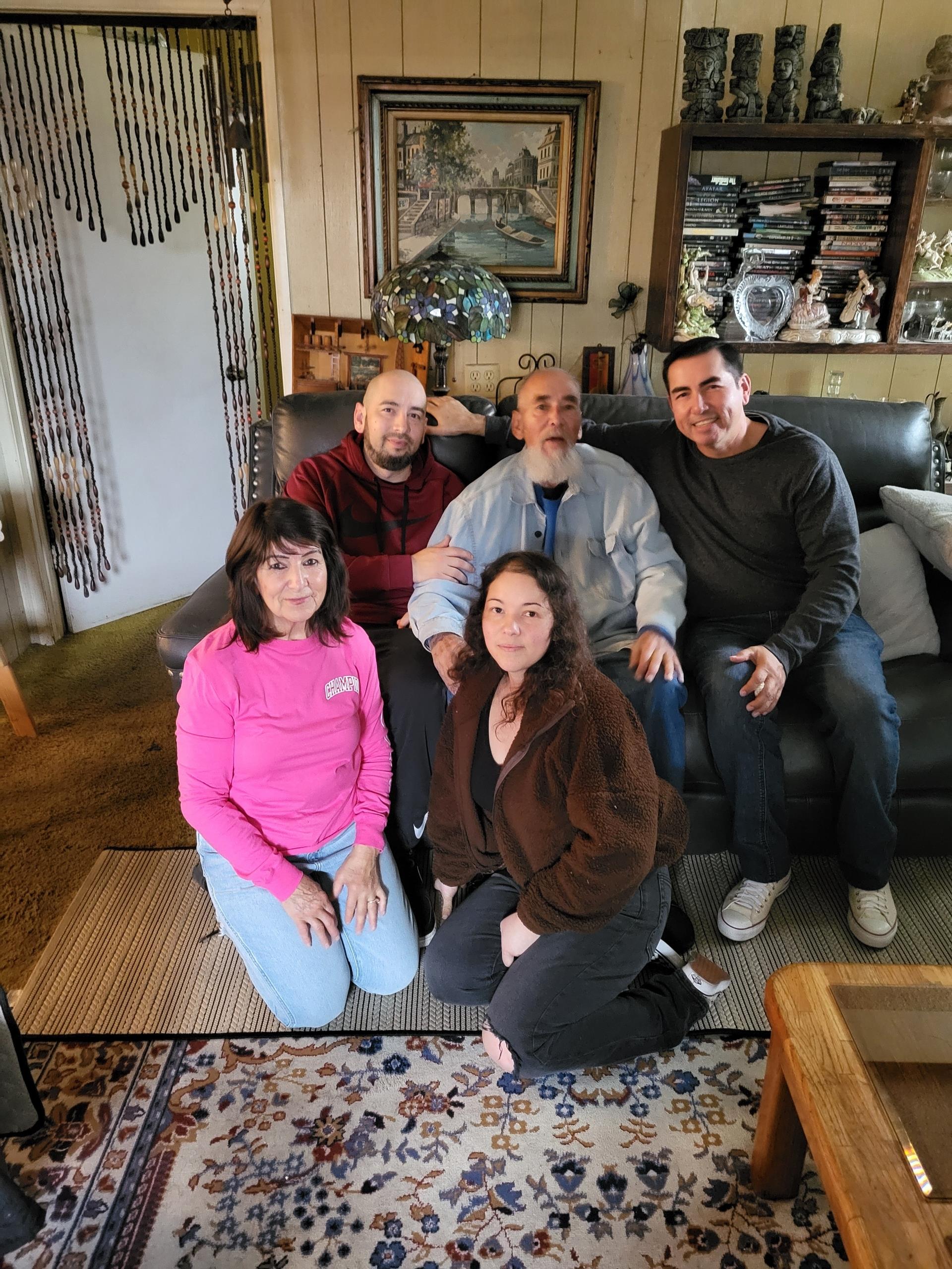 Five friends relax together in a cozy living room with warm decor.
