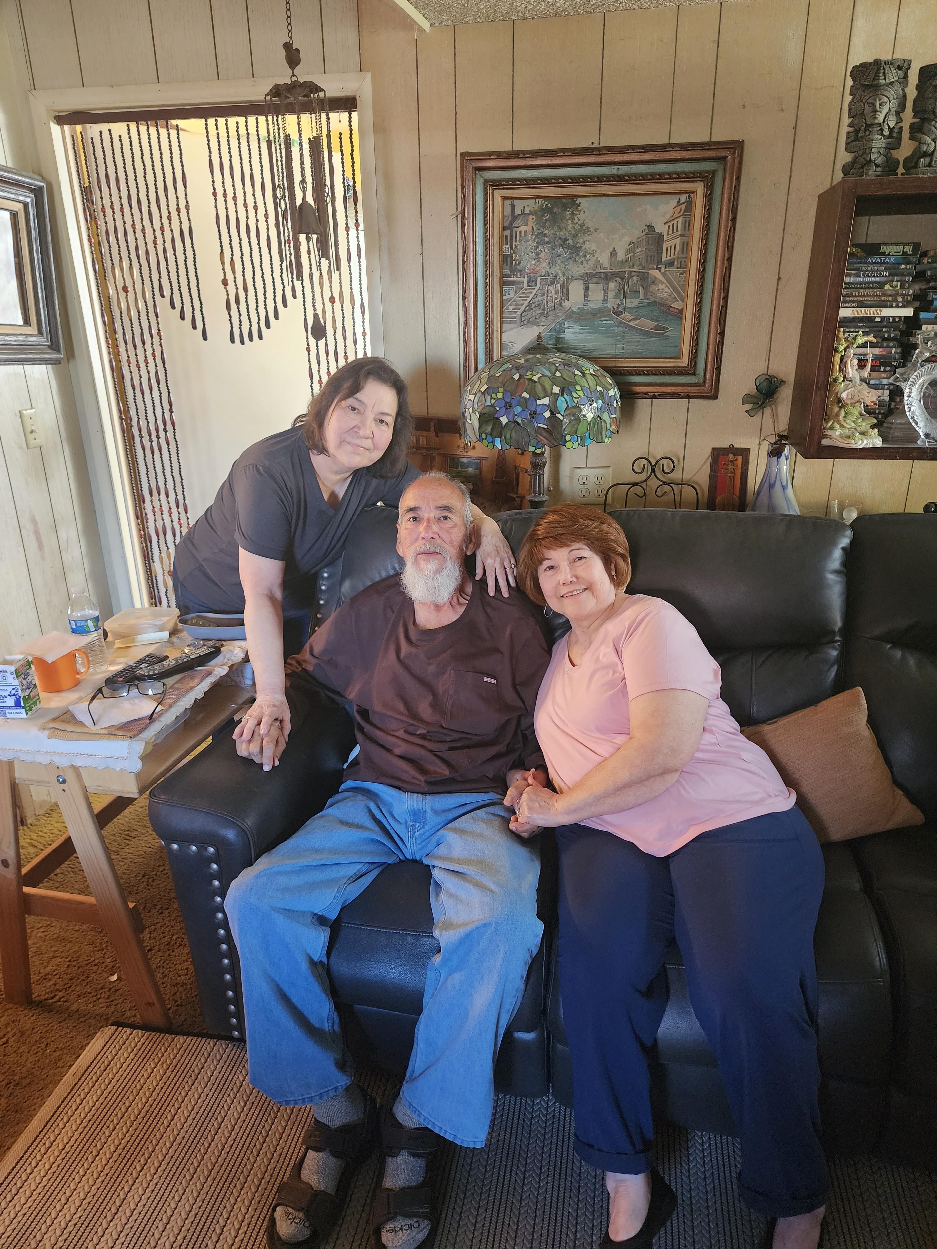 Two women and a man are enjoying a relaxing time together in a warm and inviting living room.