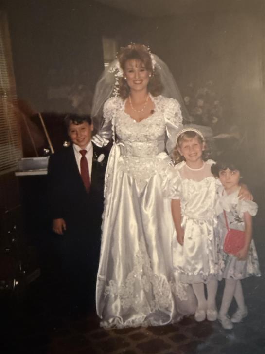 A woman in a wedding dress with children