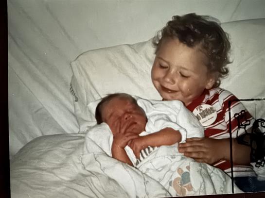 A boy holding a baby
