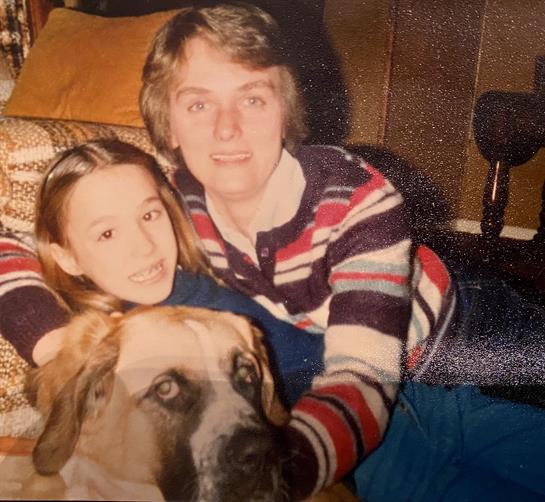 A man and a girl posing for a picture with a dog