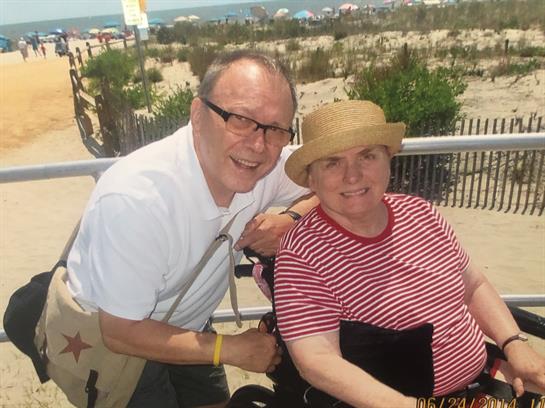 A man and woman sitting on a wheelchair
