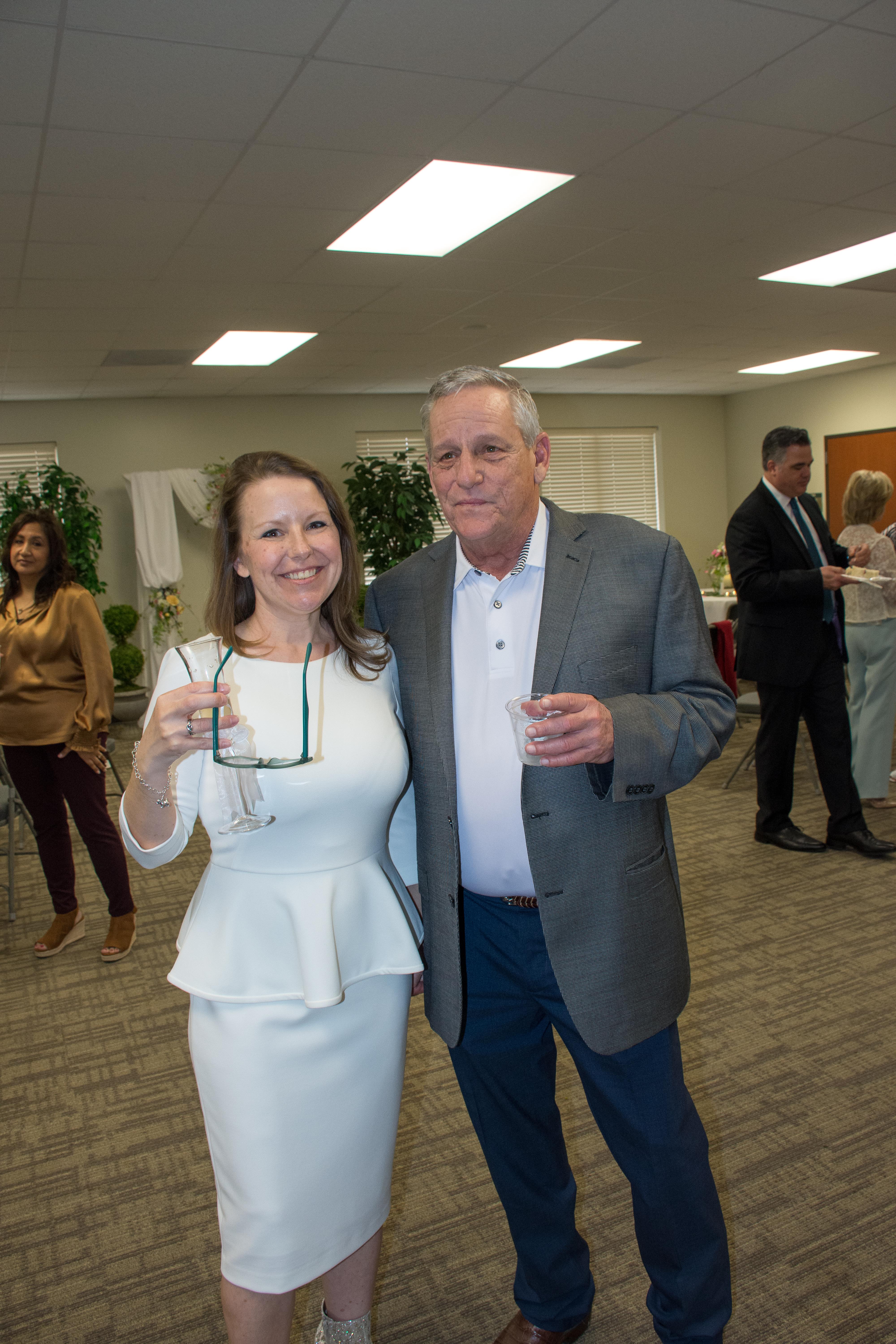 Guests are mingling and enjoying drinks during an indoor event, creating a joyful atmosphere.