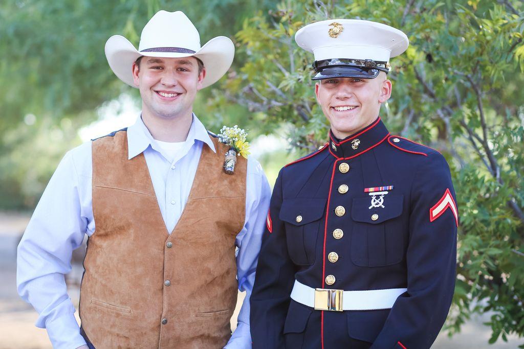Two friends smiling in a sunny location, one in a military uniform and the other in casual attire.