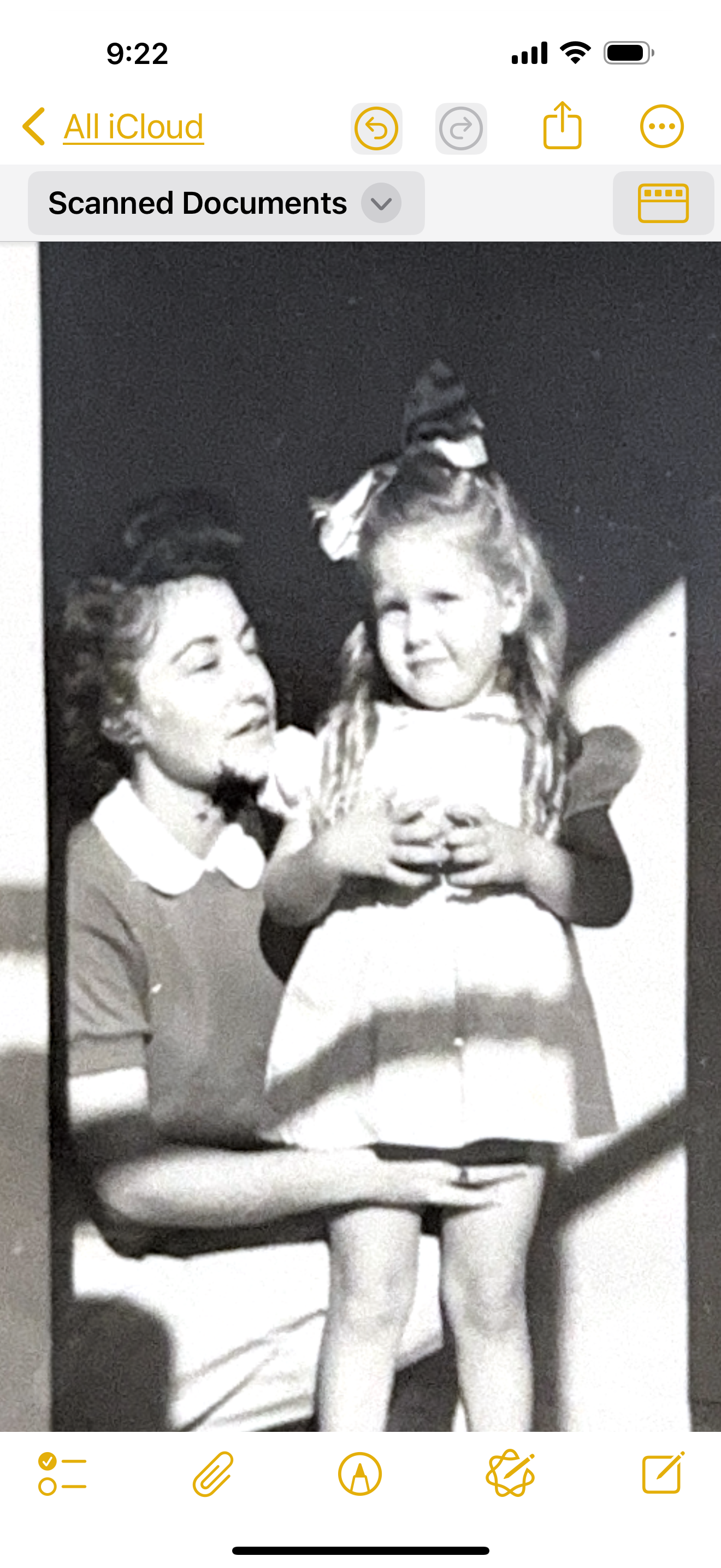 A woman lovingly holds a smiling young girl, creating a cherished family memory in black and white.