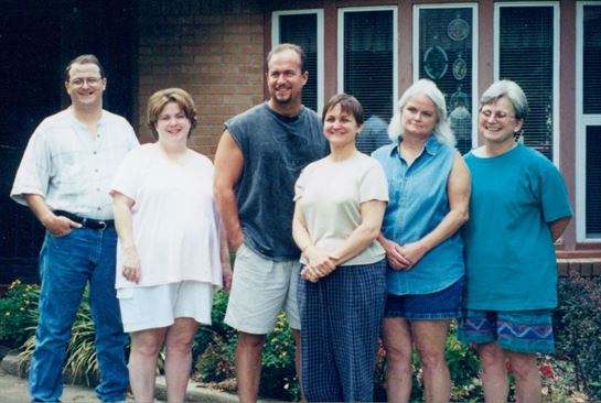 A group of people standing outside a house