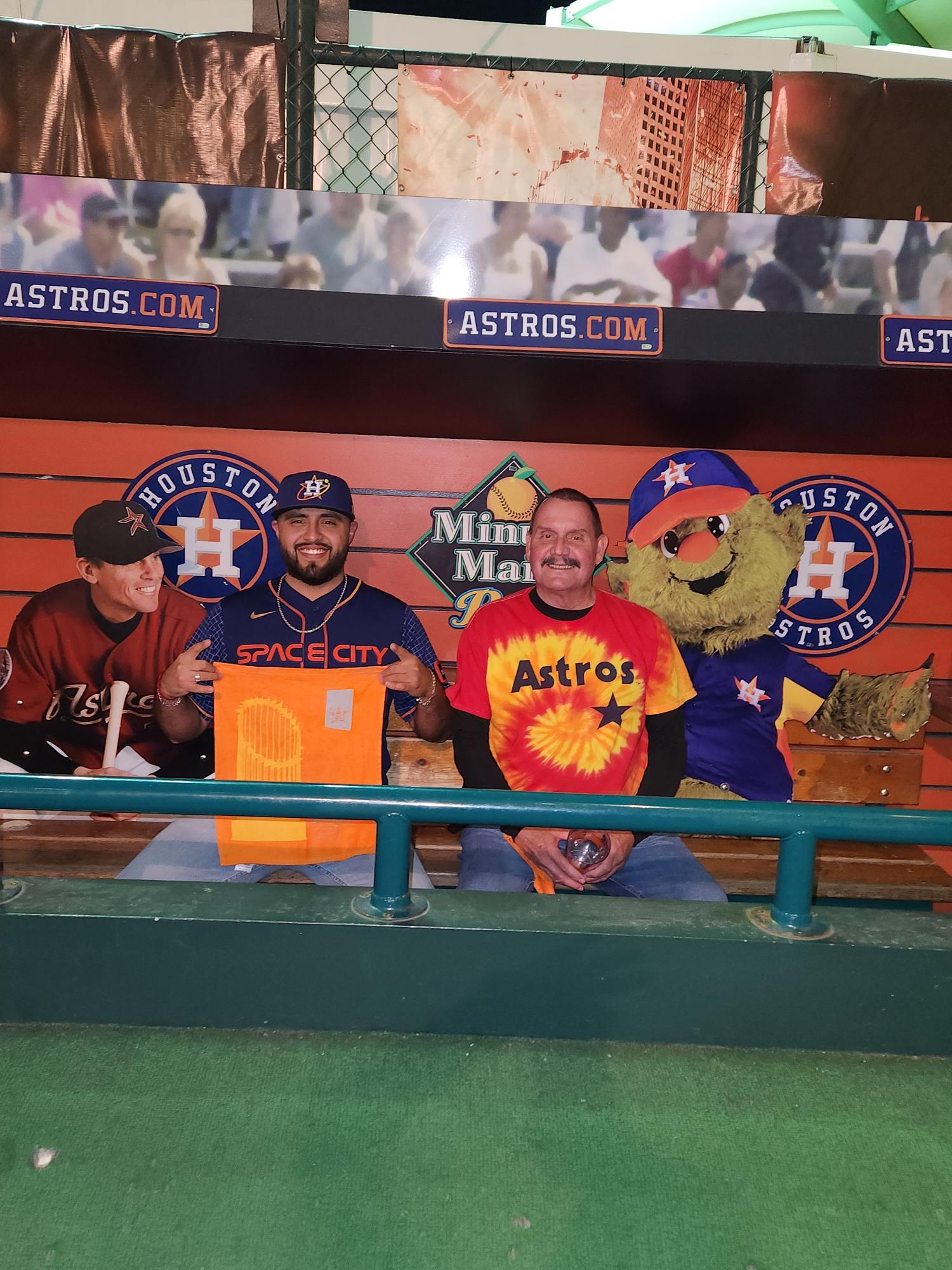 Cheerful fans dressed in team apparel enjoy a baseball game together, showcasing their enthusiasm.
