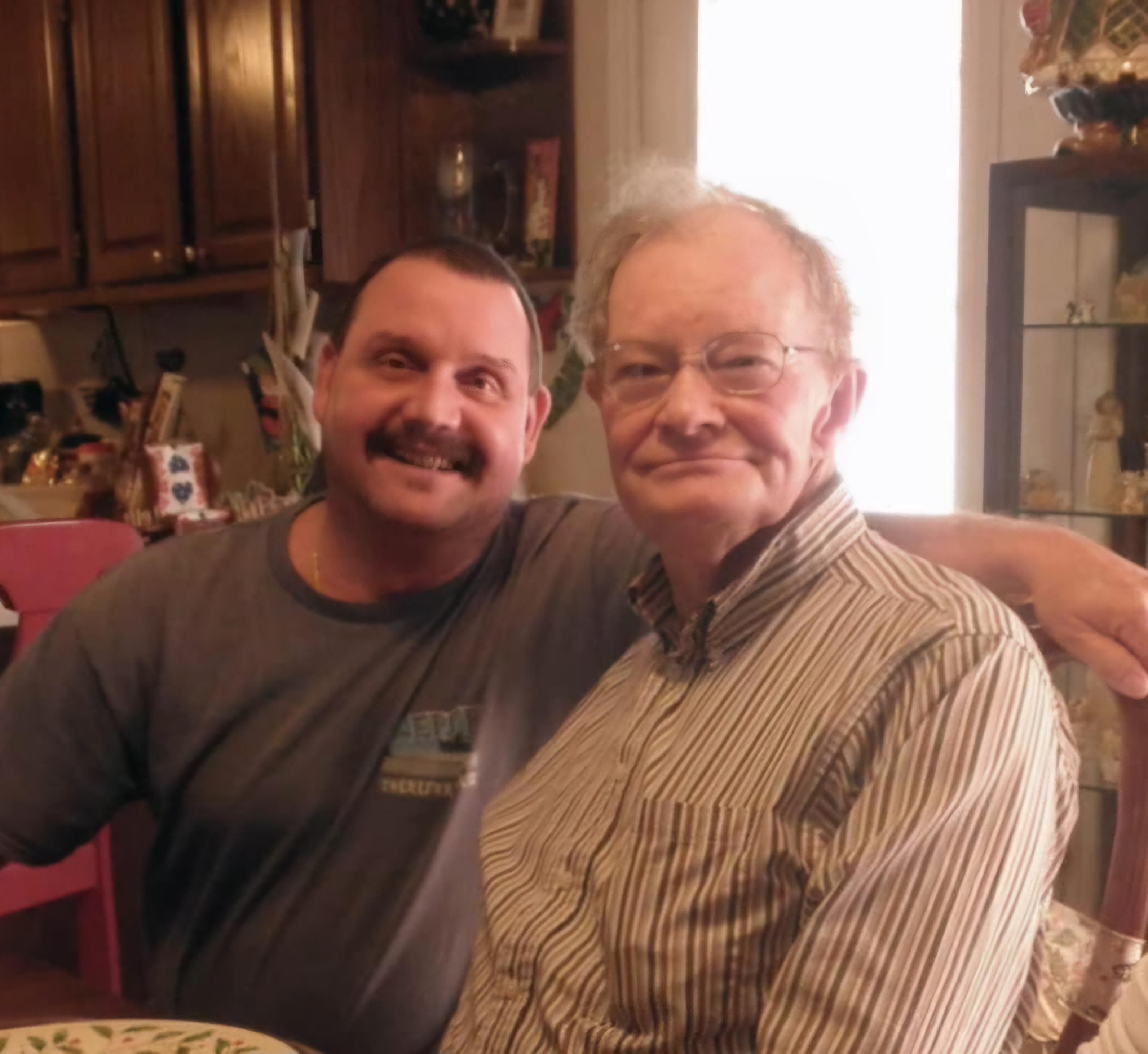Two men share a joyful moment together in a cozy home setting filled with warmth.