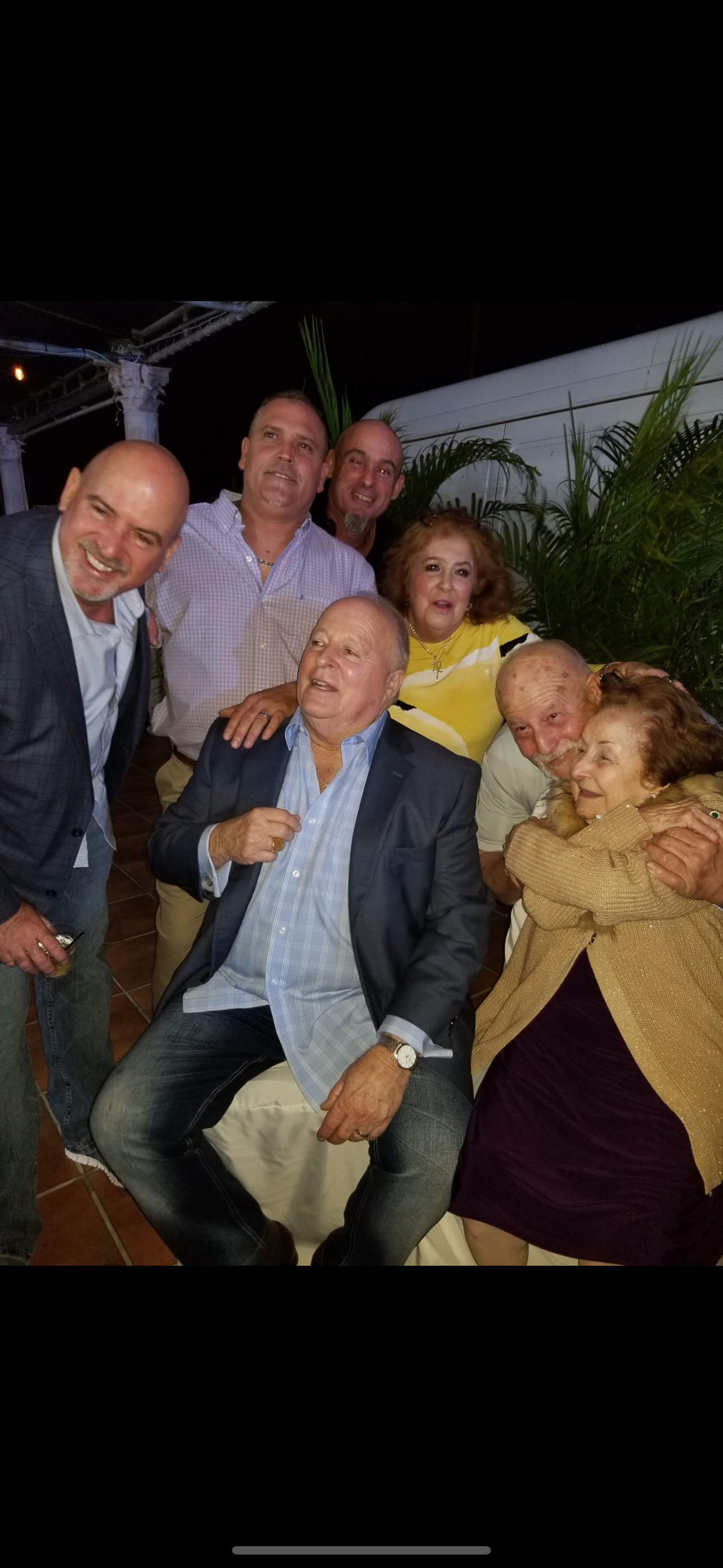 A group of adults shares laughter and stories on a warm evening.