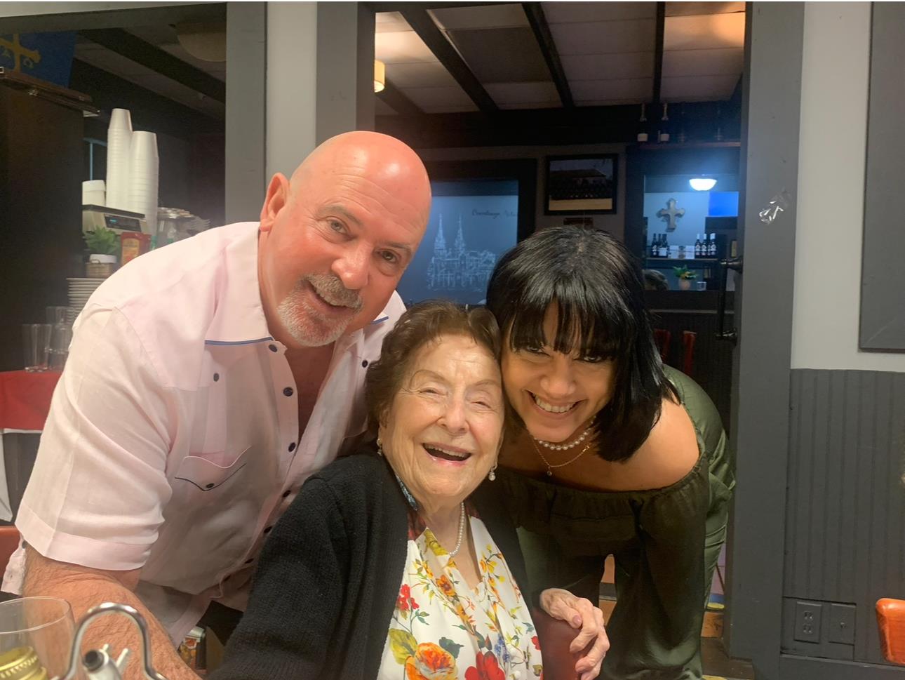 Friends and family share laughter and smiles together at a restaurant, capturing a joyful moment.