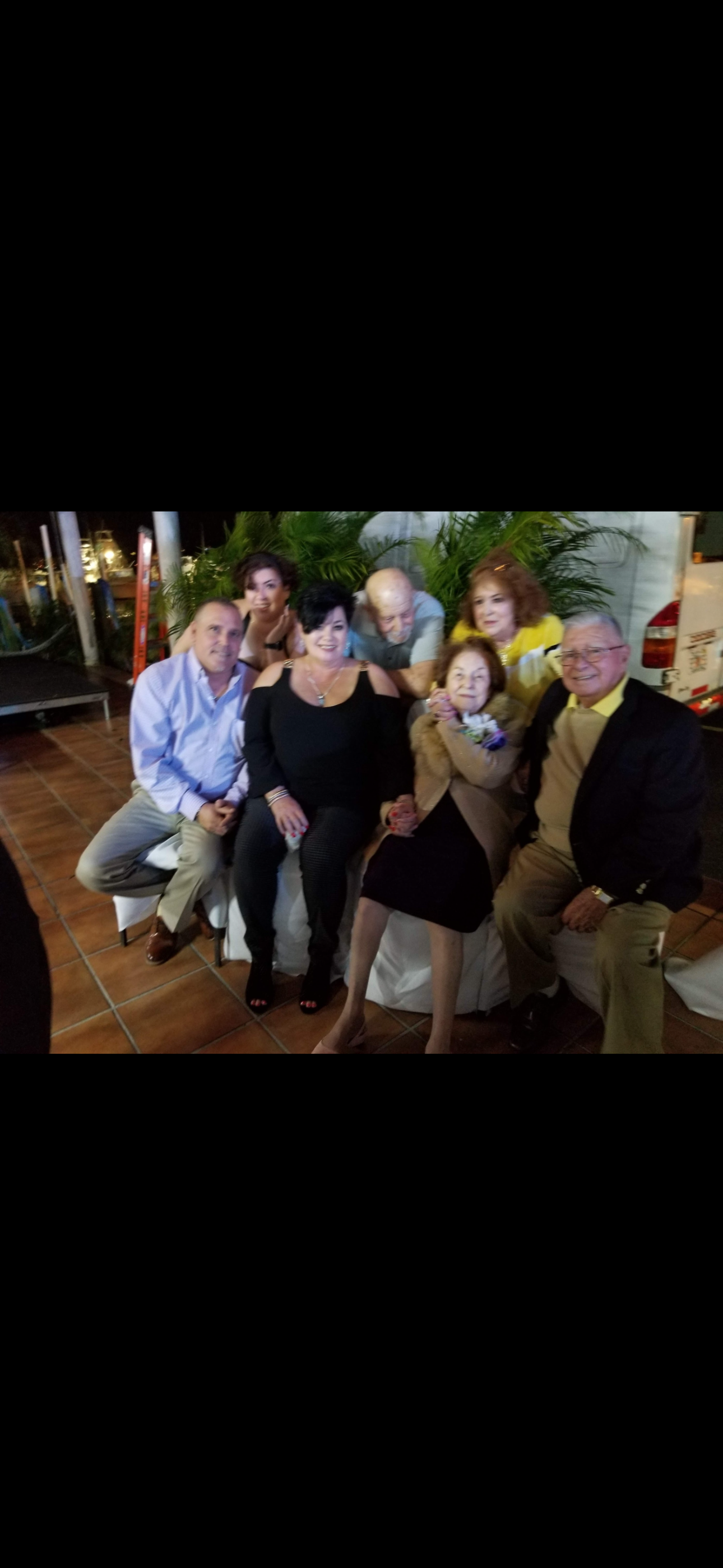 Friends enjoy each other's company at a lively outdoor celebration surrounded by greenery.