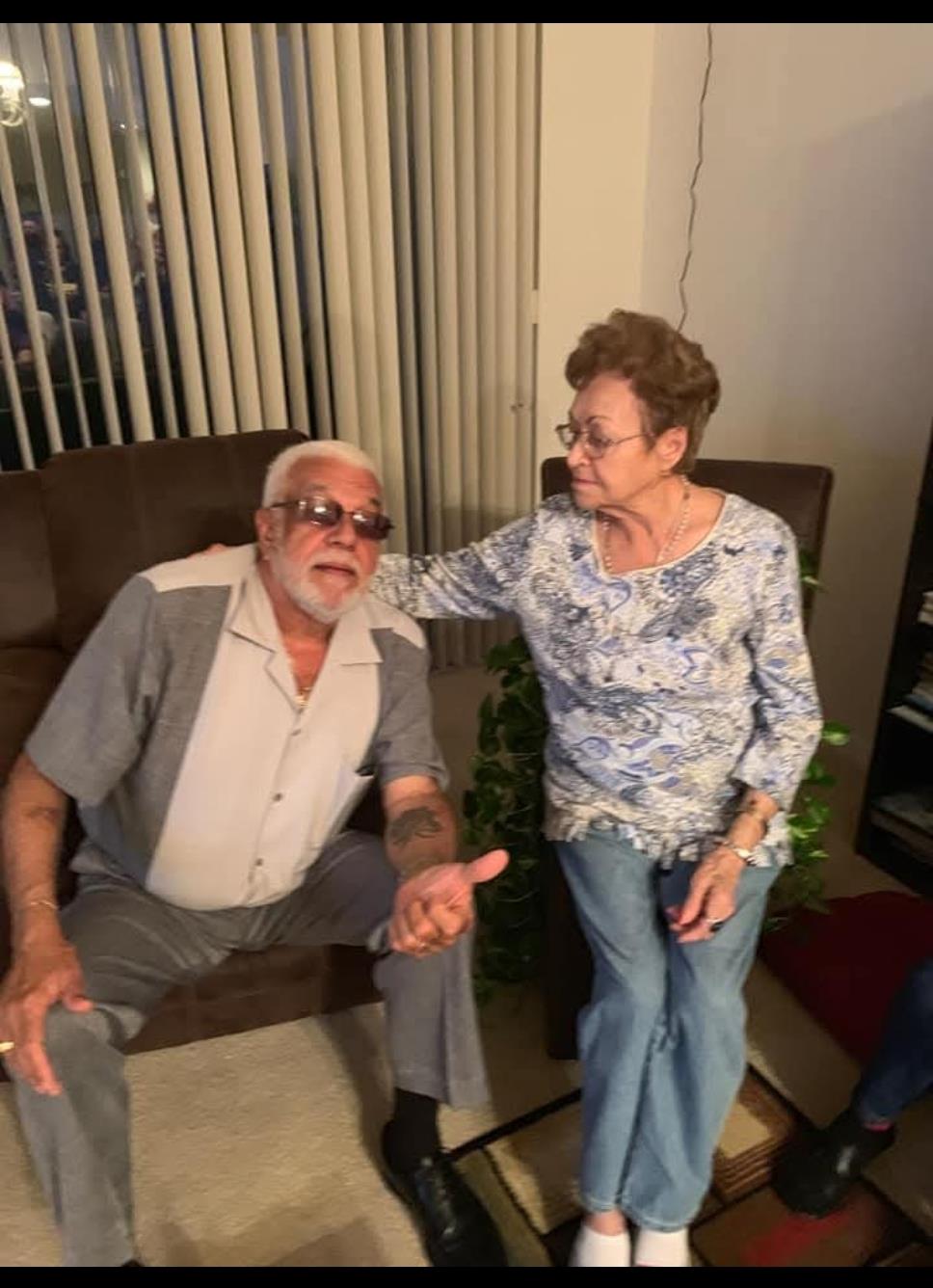 Elderly couple sharing laughter and stories while seated in their inviting living room.