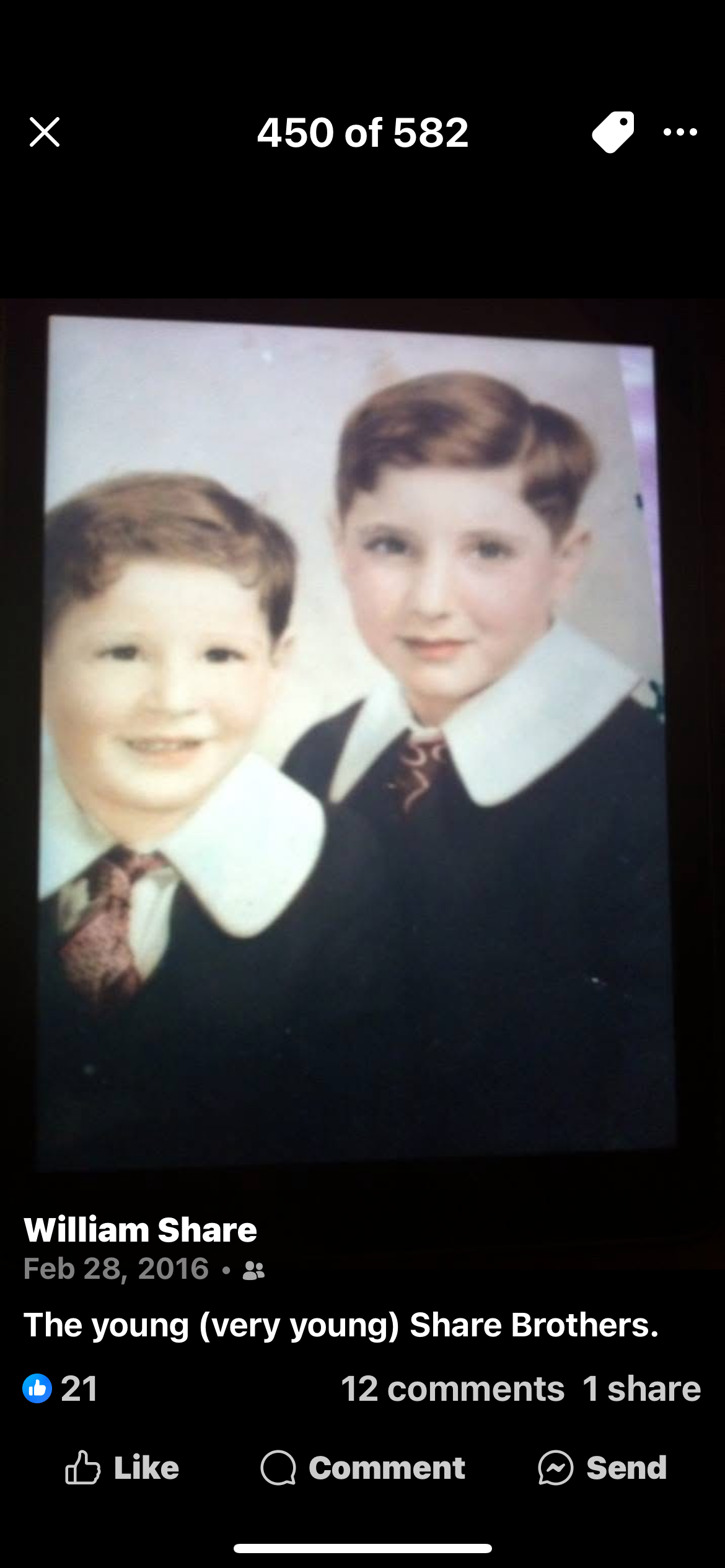 Two young boys pose smiling for a portrait, showcasing early 20th century fashion.