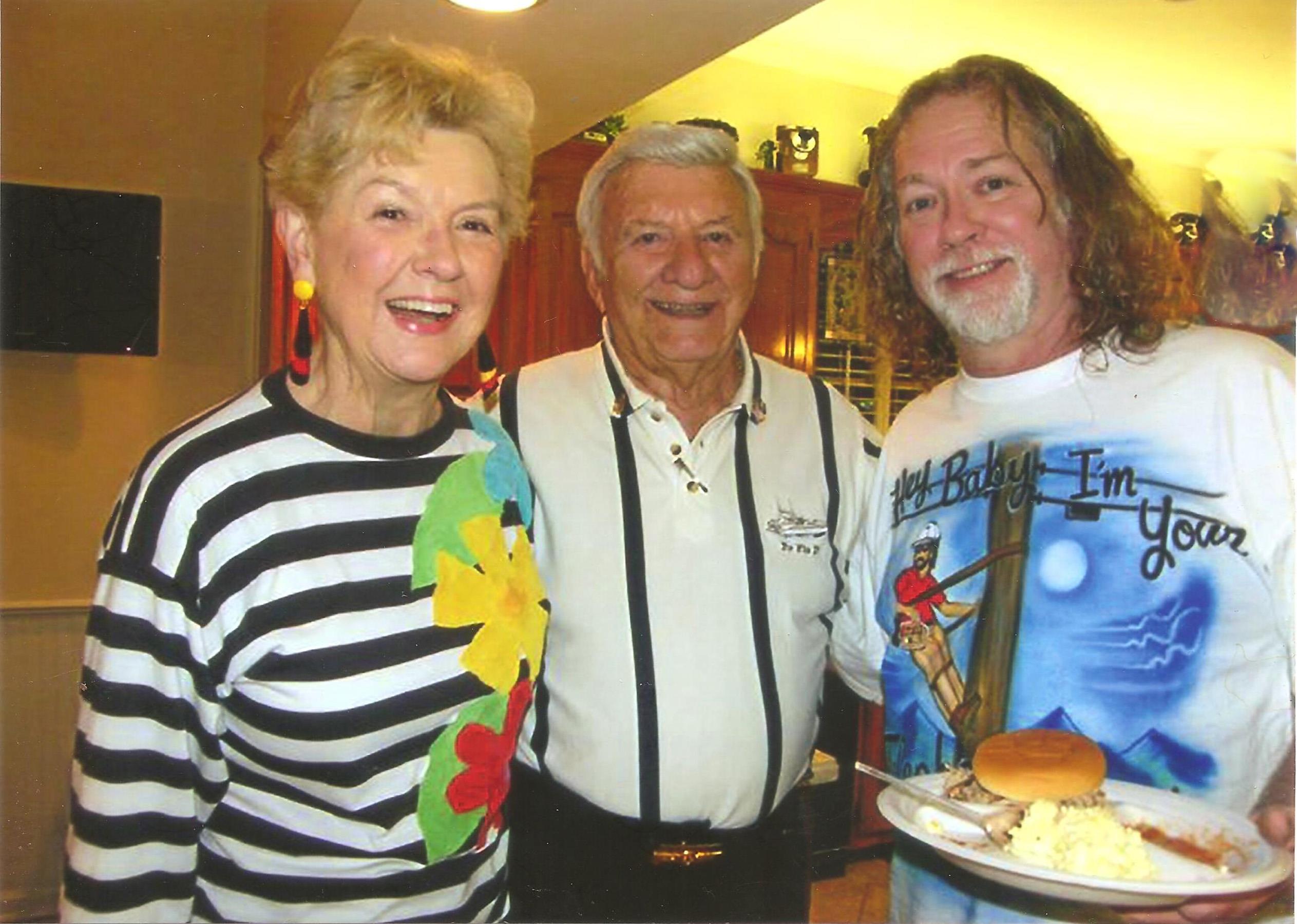 Three friends share smiles and a meal together in a warm, inviting environment filled with laughter.
