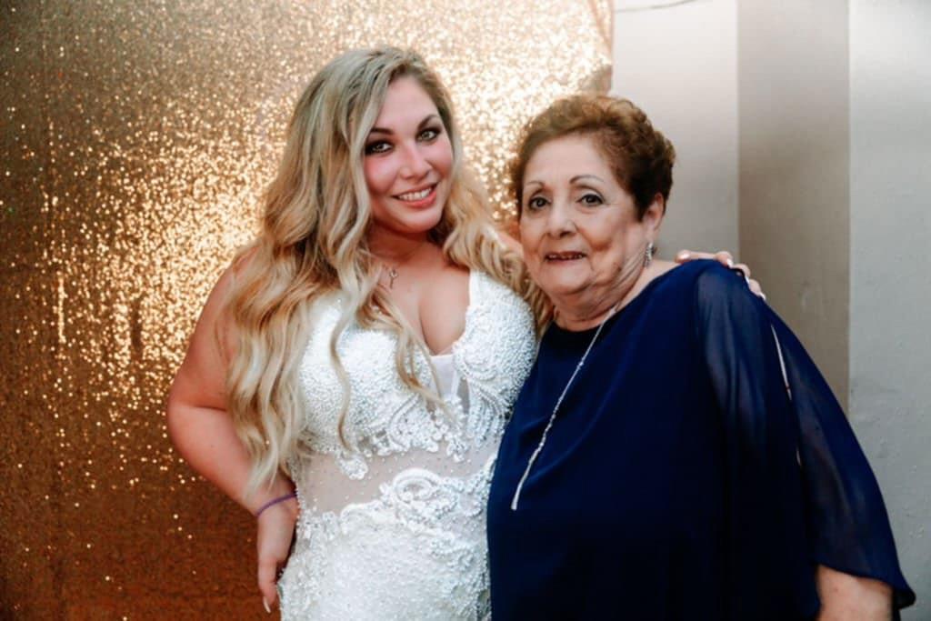 Two women pose together joyfully, showcasing a loving family connection at a wedding reception.