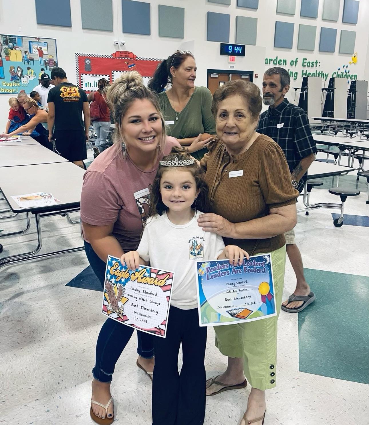 Families gathered in a school cafeteria to celebrate students' achievements and awards.