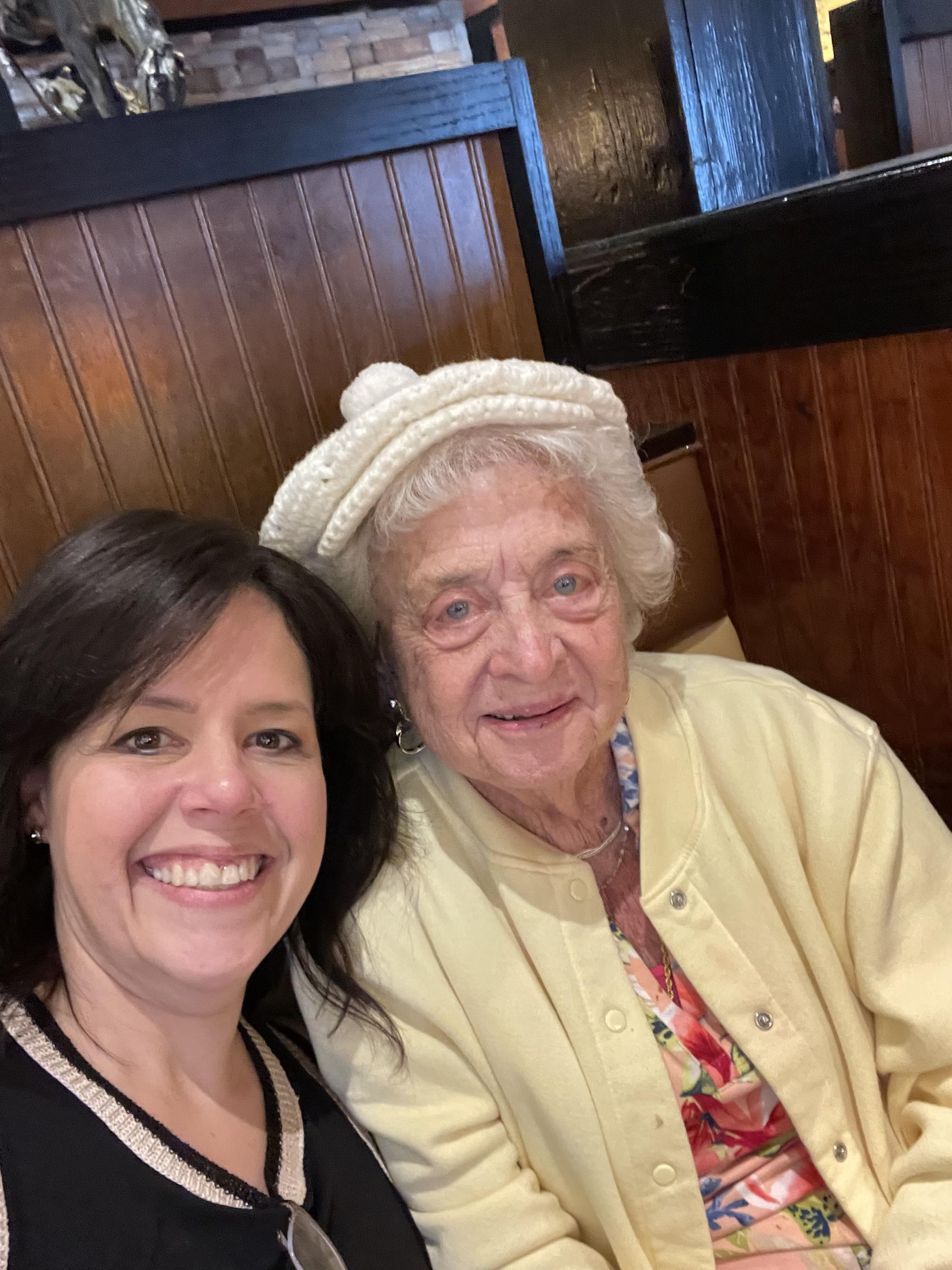 Two women share a joyful moment at a restaurant, celebrating their bond and memories together.