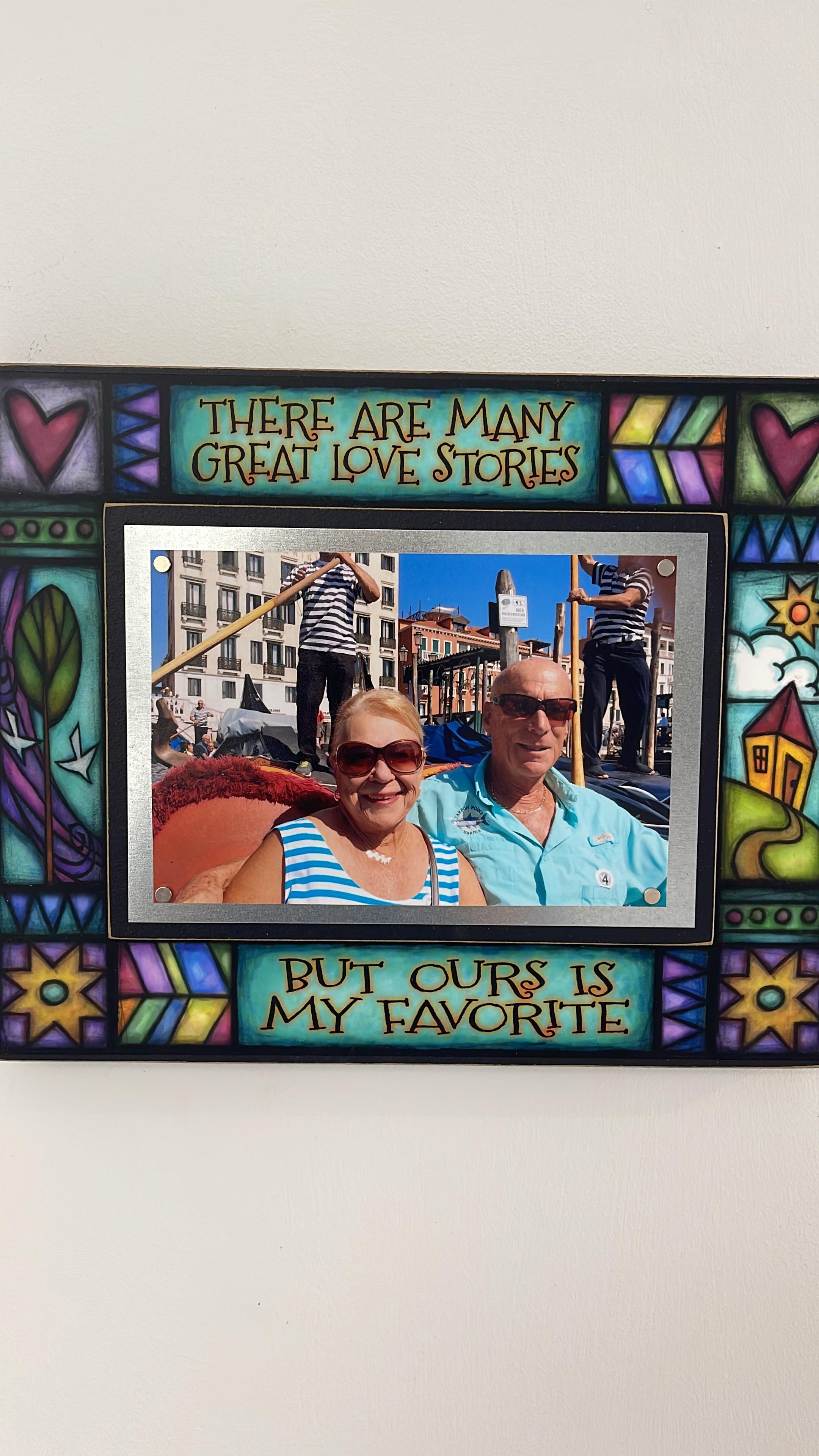 A couple smiles for a candid photo, celebrating their love in a colorful coastal setting.