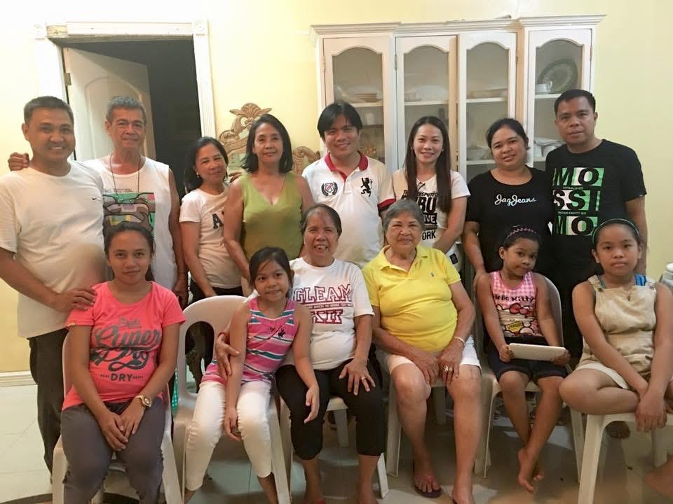 A large family enjoys time together in a bright living room filled with laughter and joy.