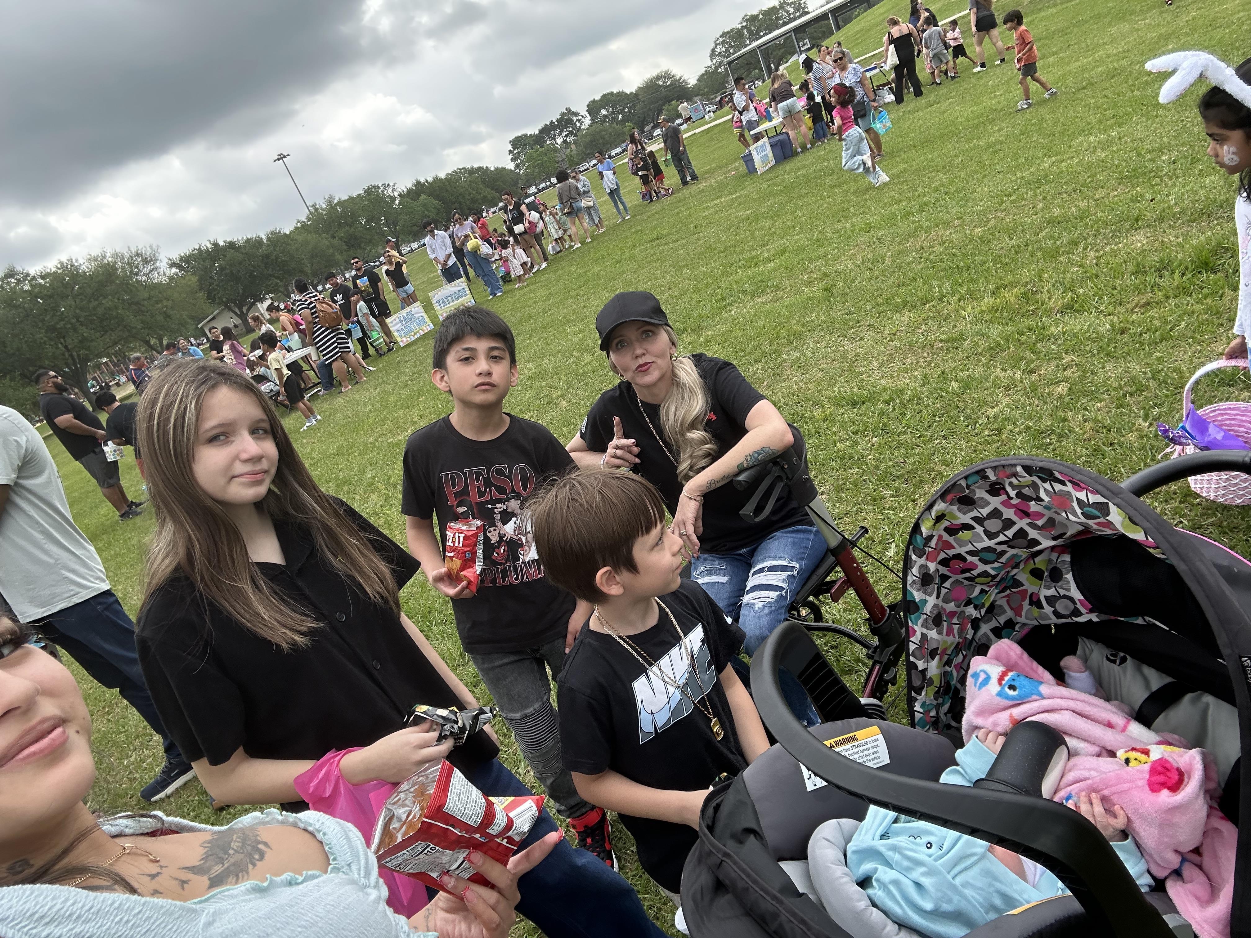 Families enjoy snacks and activities together at a park during a community gathering