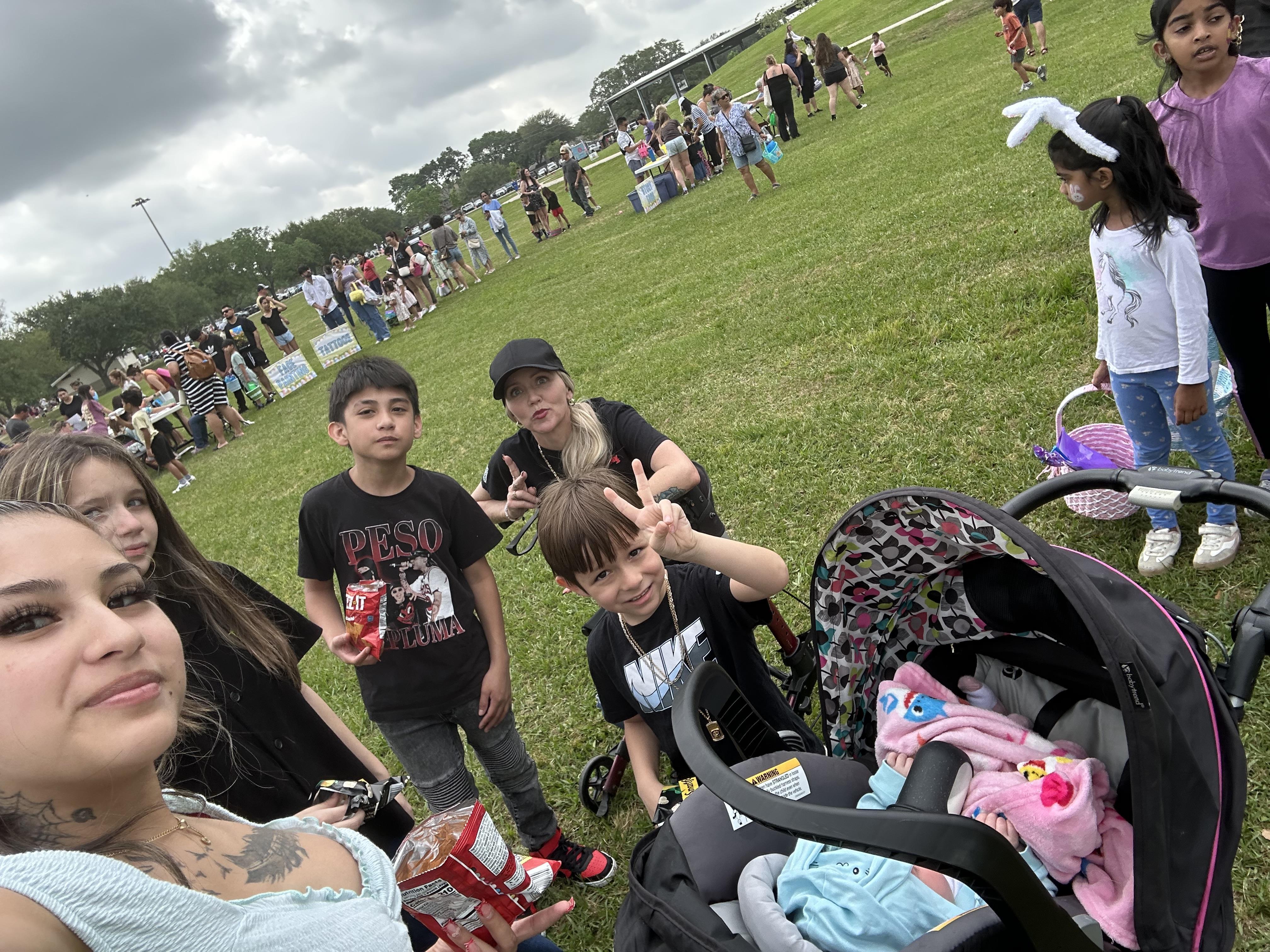 Families gather at a park event, enjoying outdoor activities, food, and fun together with children.