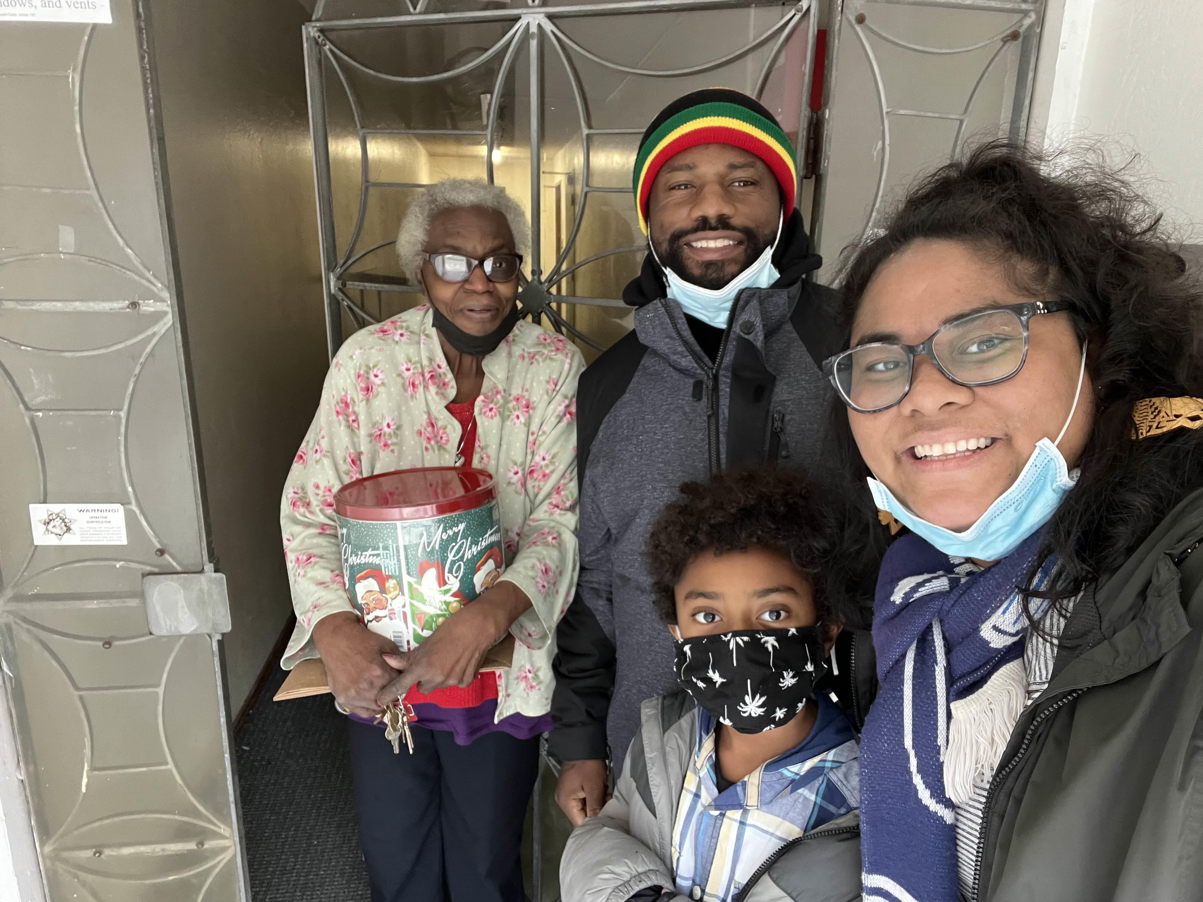 Family and friends gather at community center, sharing joy and holiday gifts during winter.