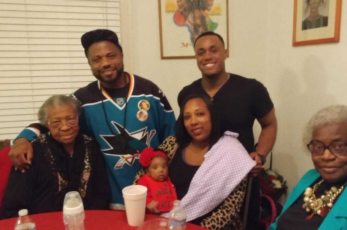 Family members gather around a table, sharing joy and laughter during a cozy evening at home.