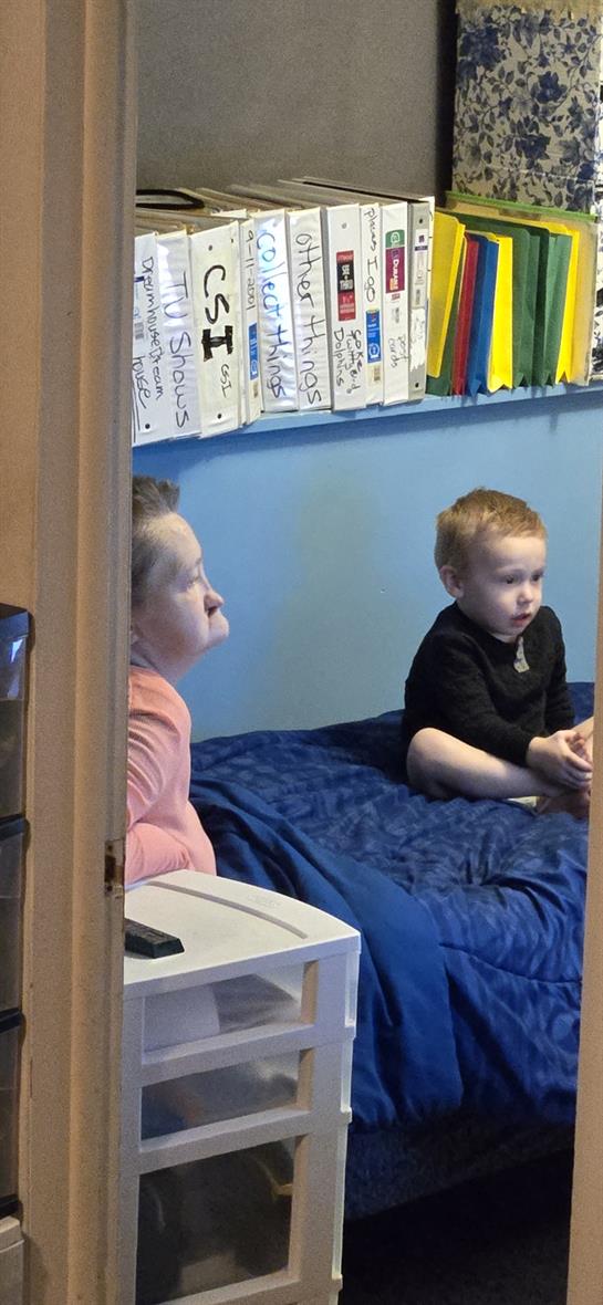 A woman and a boy sitting on a bed