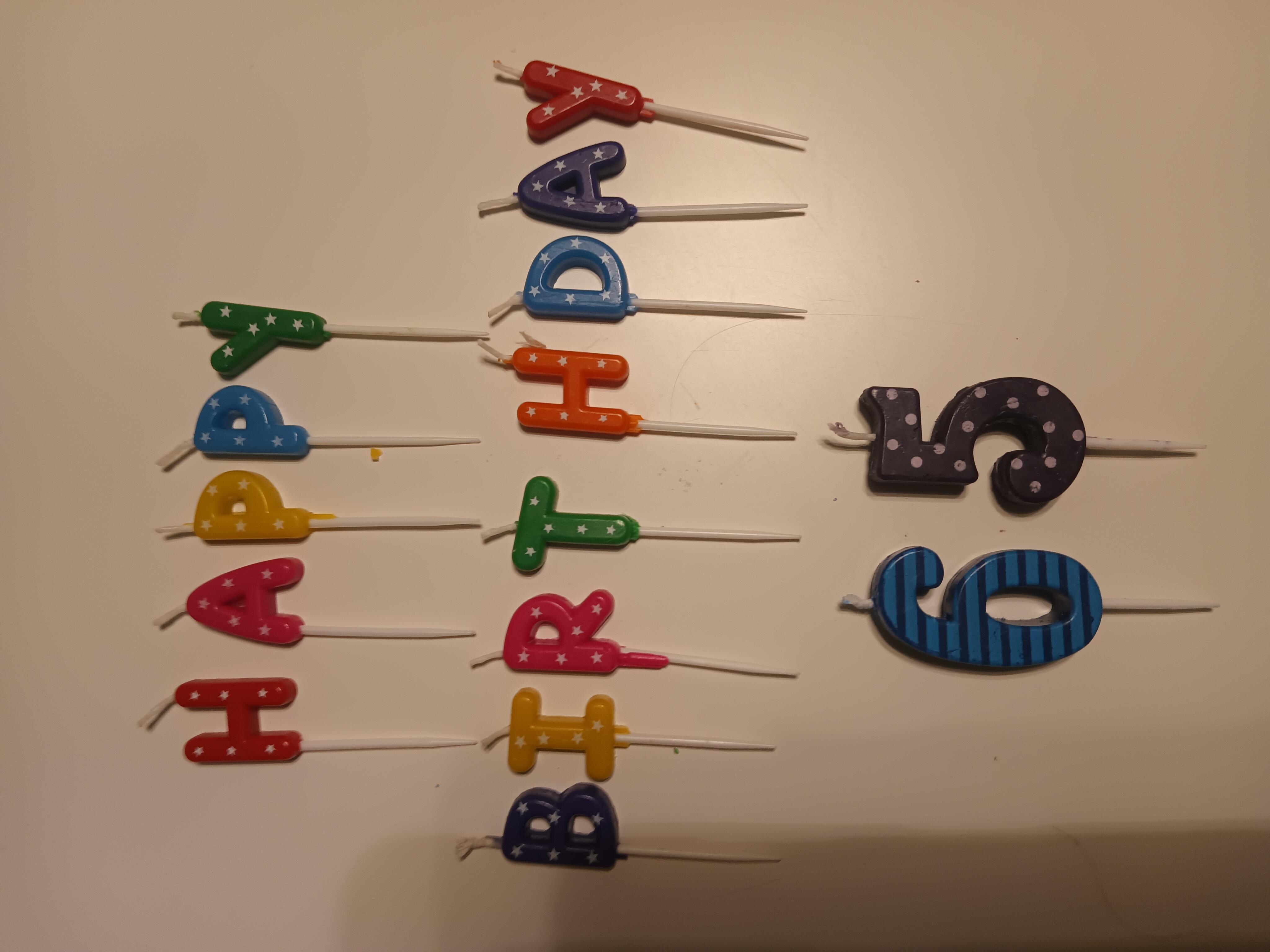 Colorful candles spell out happy birthday, celebrating a child's sixth birthday with joy.