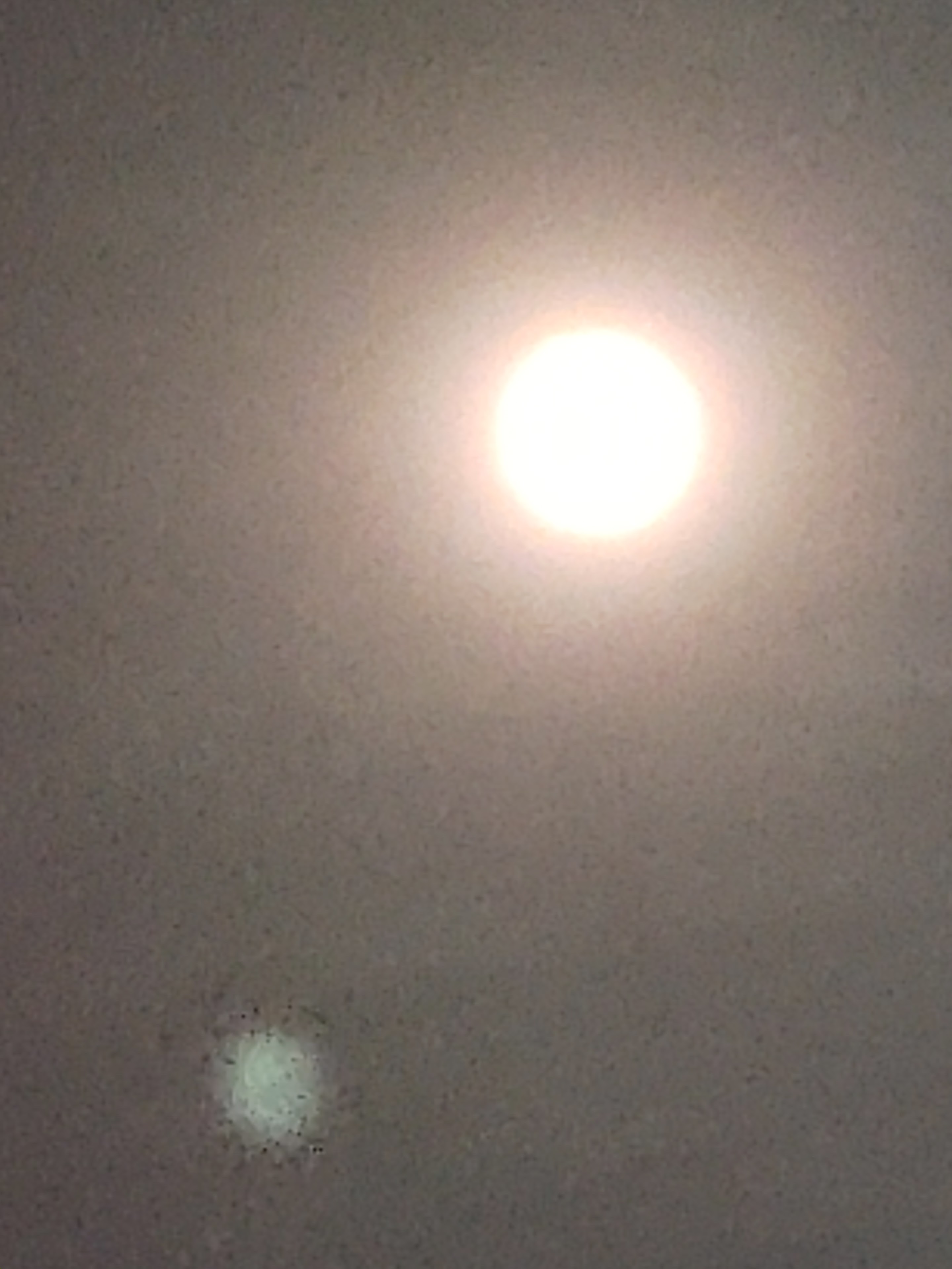 A full moon shines brightly in the night sky, casting a soft glow over serene clouds and shadows.