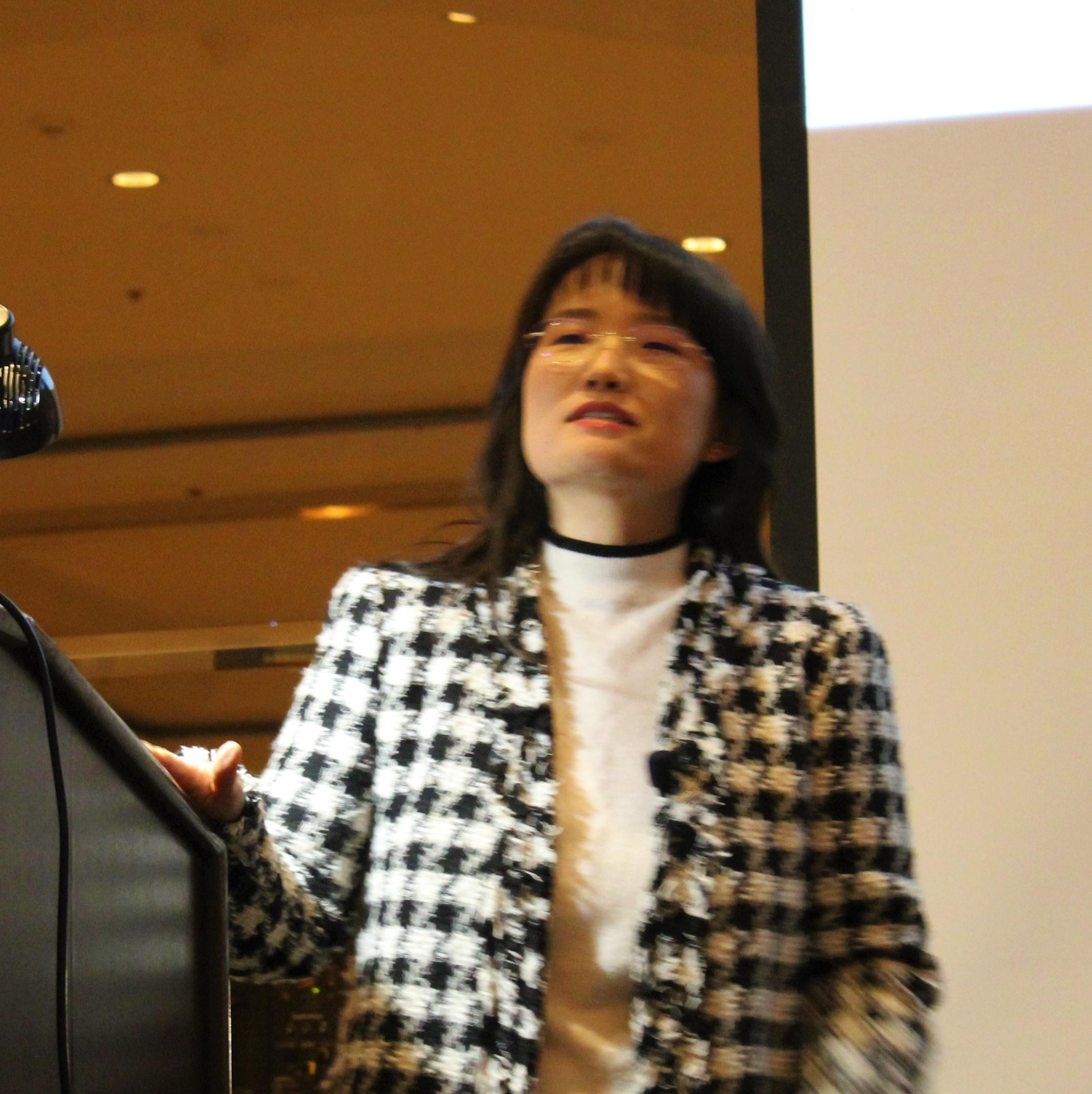 A speaker discusses important technology trends at a conference in a large meeting room.