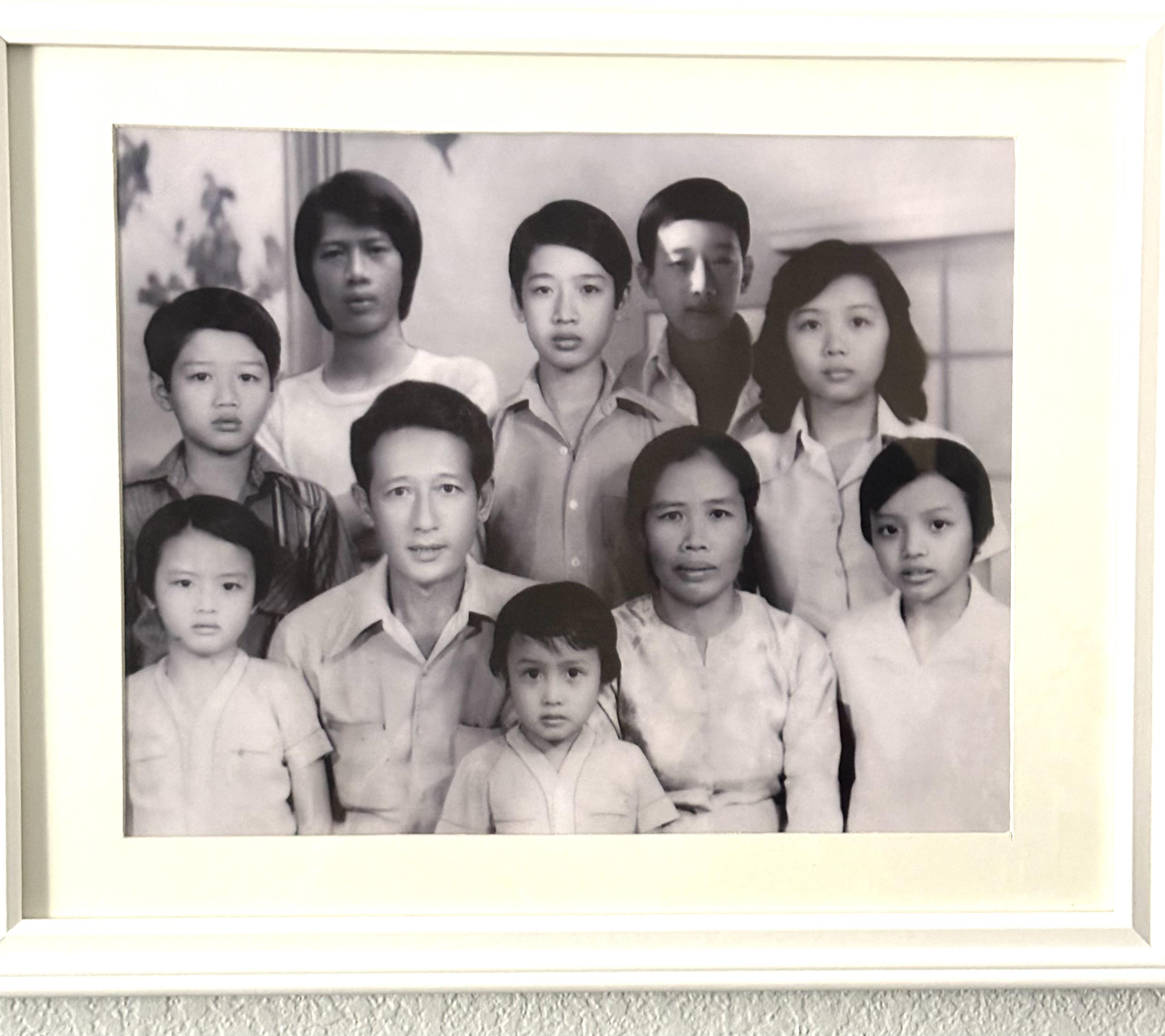 A large family poses together, showcasing various generations in a nostalgic setting.