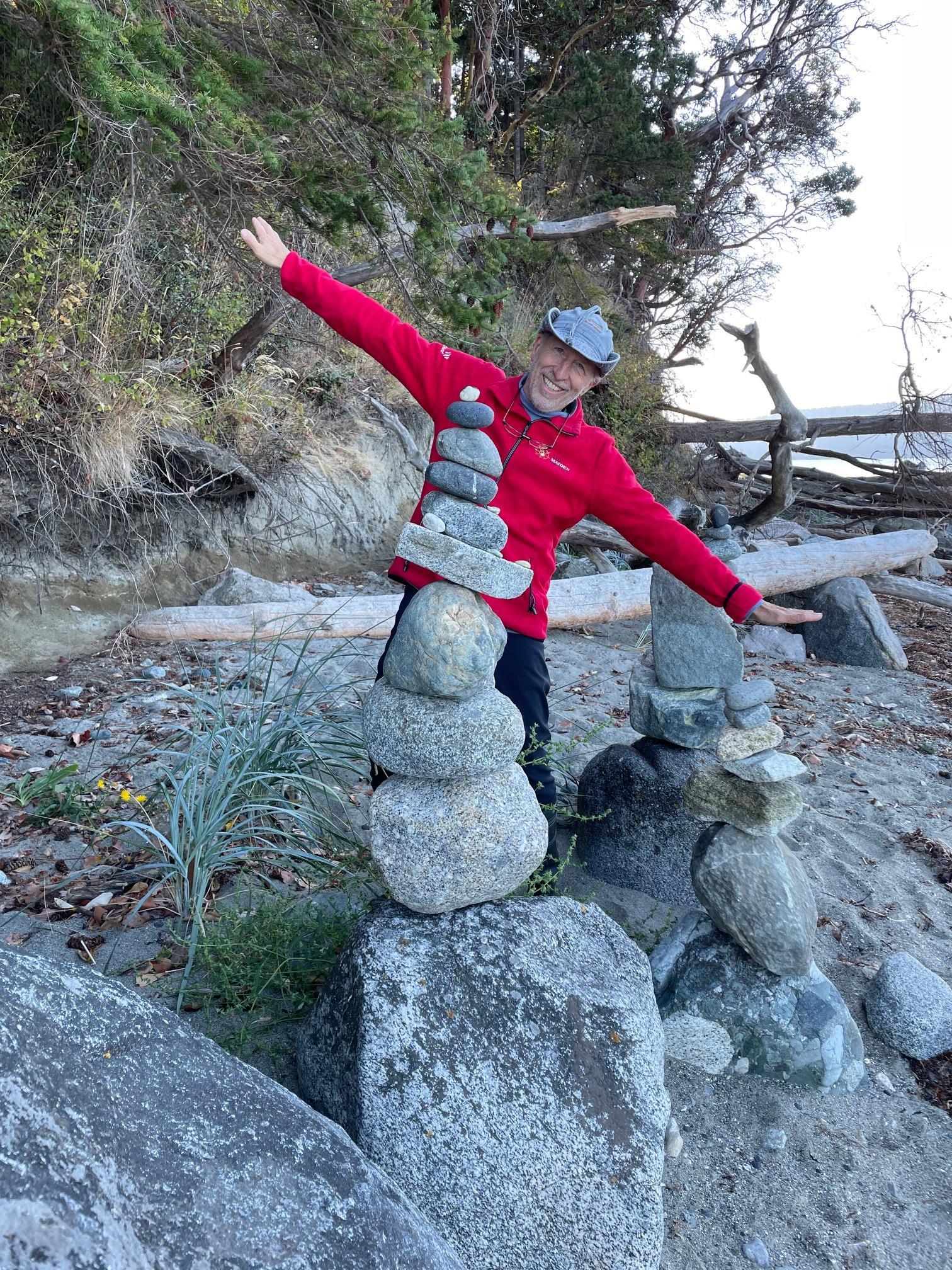 Building stone towers on a serene beach while embracing the beauty of nature and sunshine.