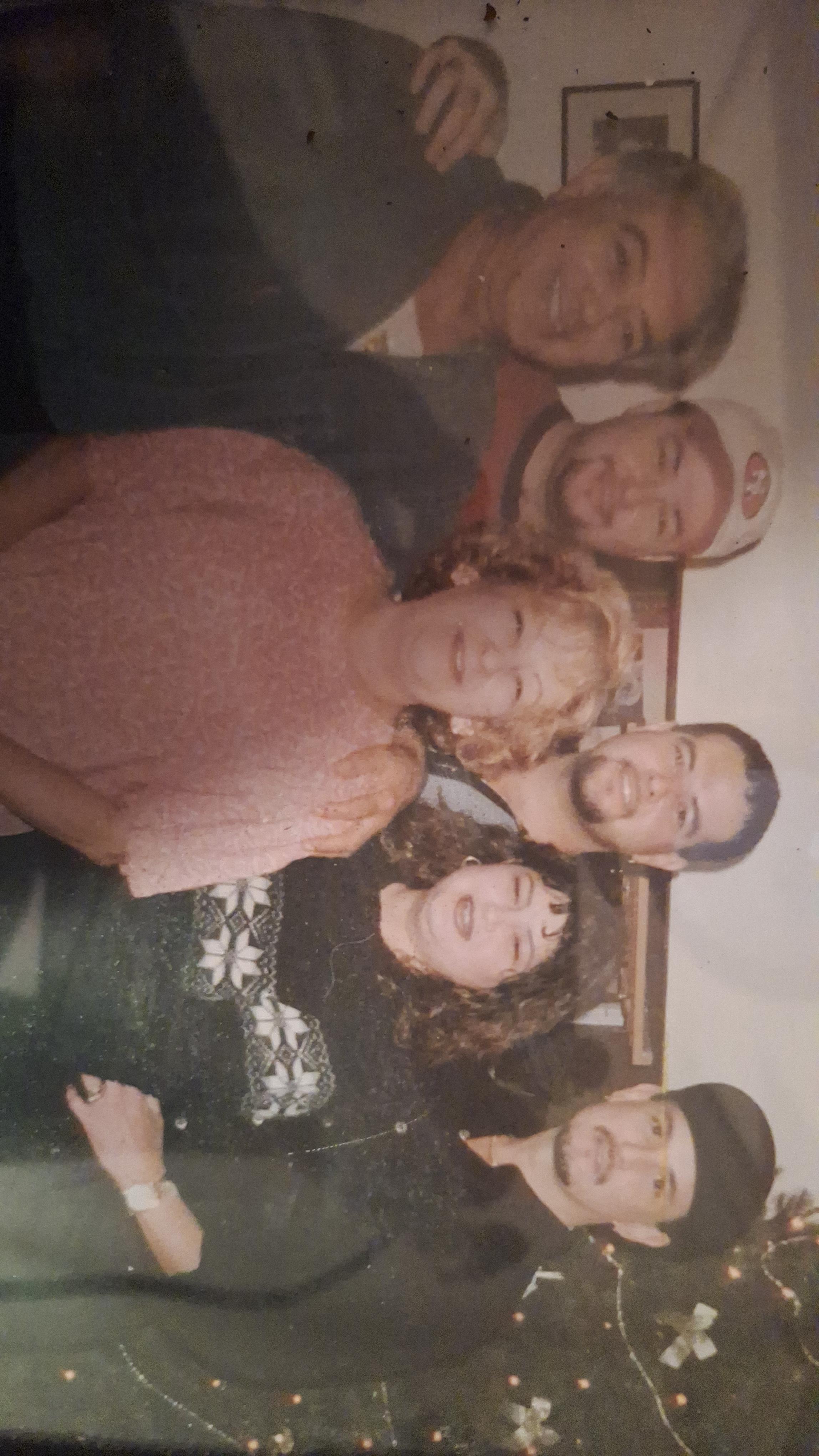 A group of friends smiles and poses together, celebrating in a warm and inviting space.