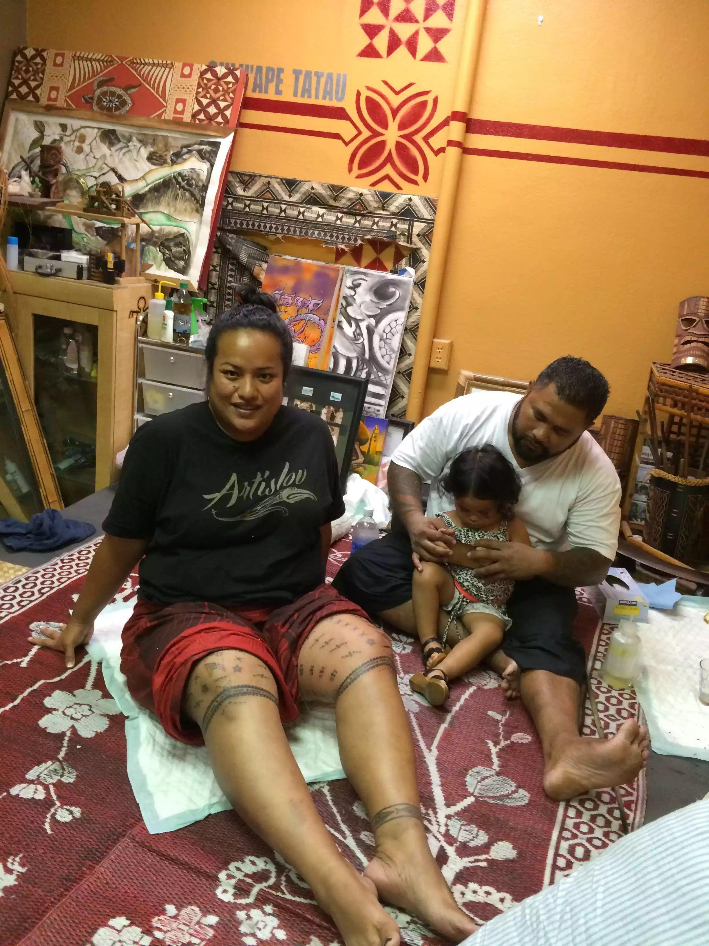A group enjoys a tattoo session in a colorful Polynesian studio, showcasing cultural artistry.