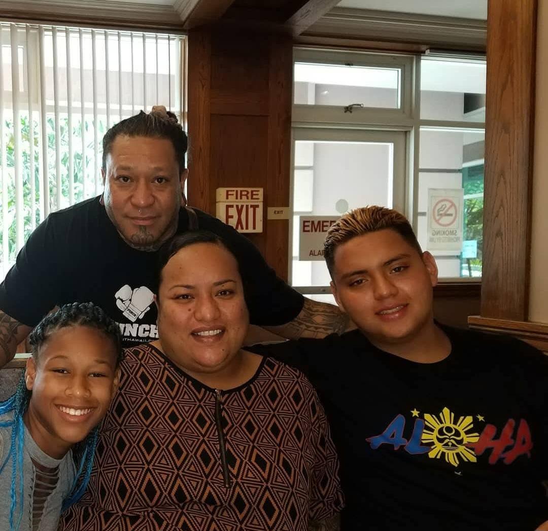 Friends and family pose happily at a restaurant, enjoying a moment together in good company.
