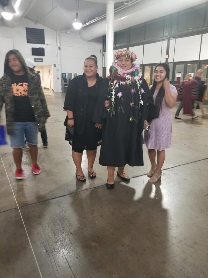 Four individuals smile together, showcasing their vibrant attire at a lively community gathering.