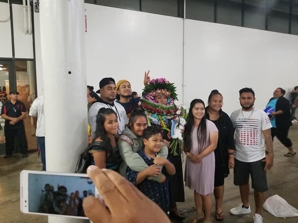Celebration takes place indoors with a performer in traditional garb surrounded by an excited group.
