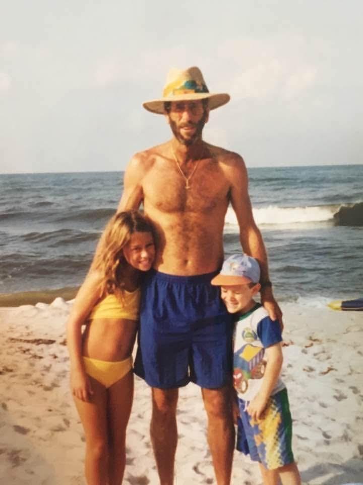 A man and two children on a beach