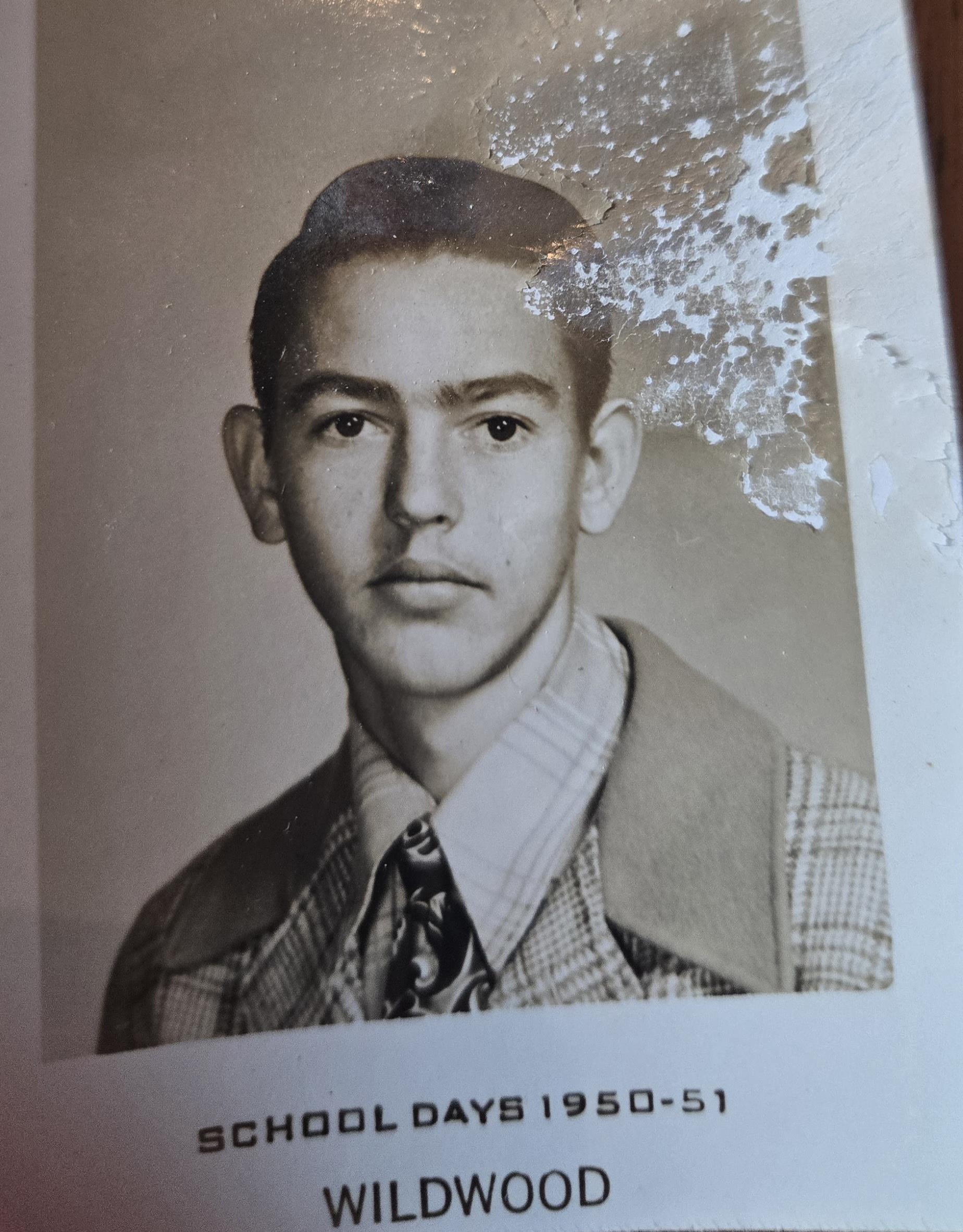 A young male student poses confidently in a formal outfit with a patterned tie from the early 1950s.