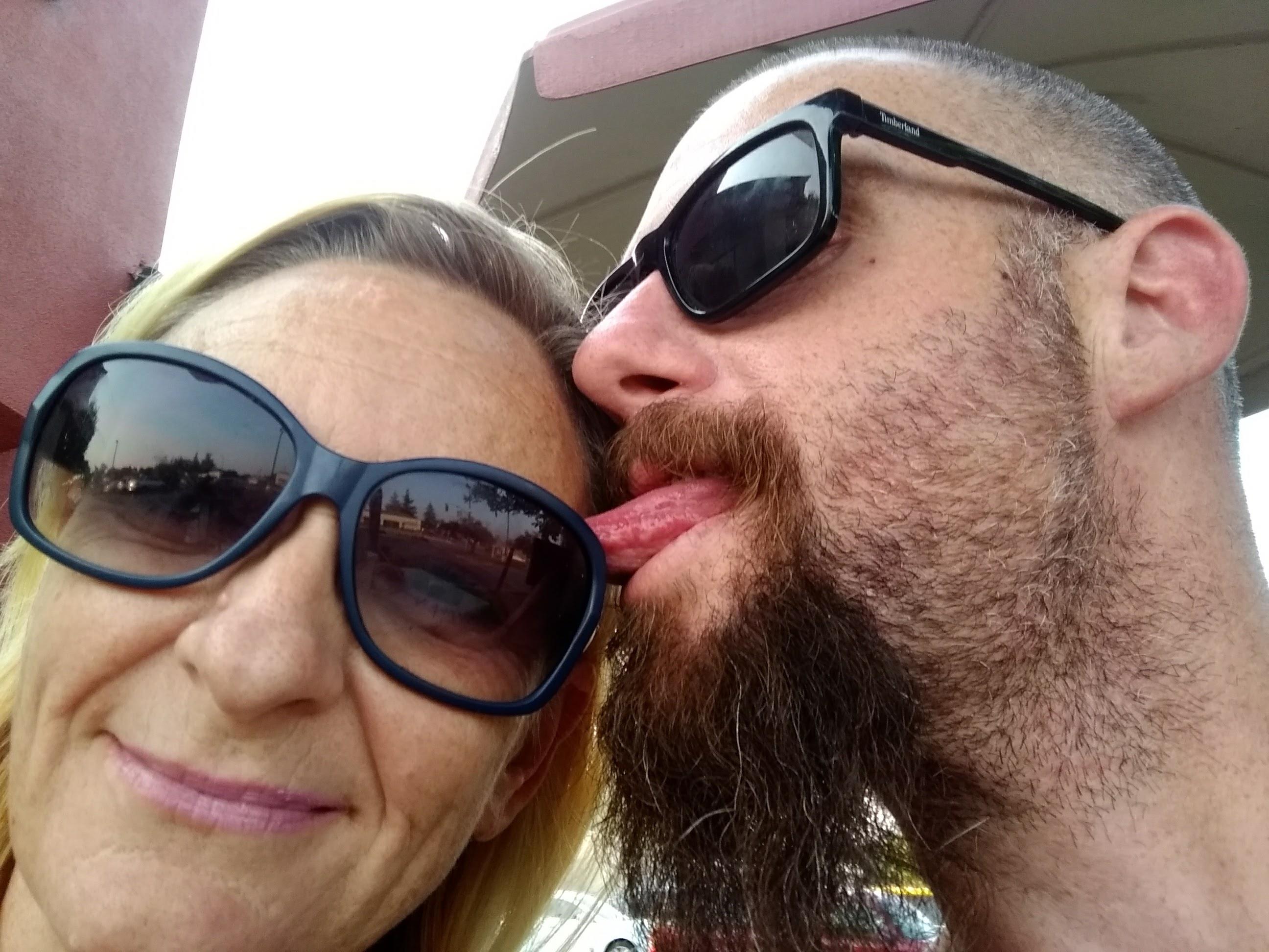 Two people share smiles and laughter outdoors, enjoying a playful moment in the sun.