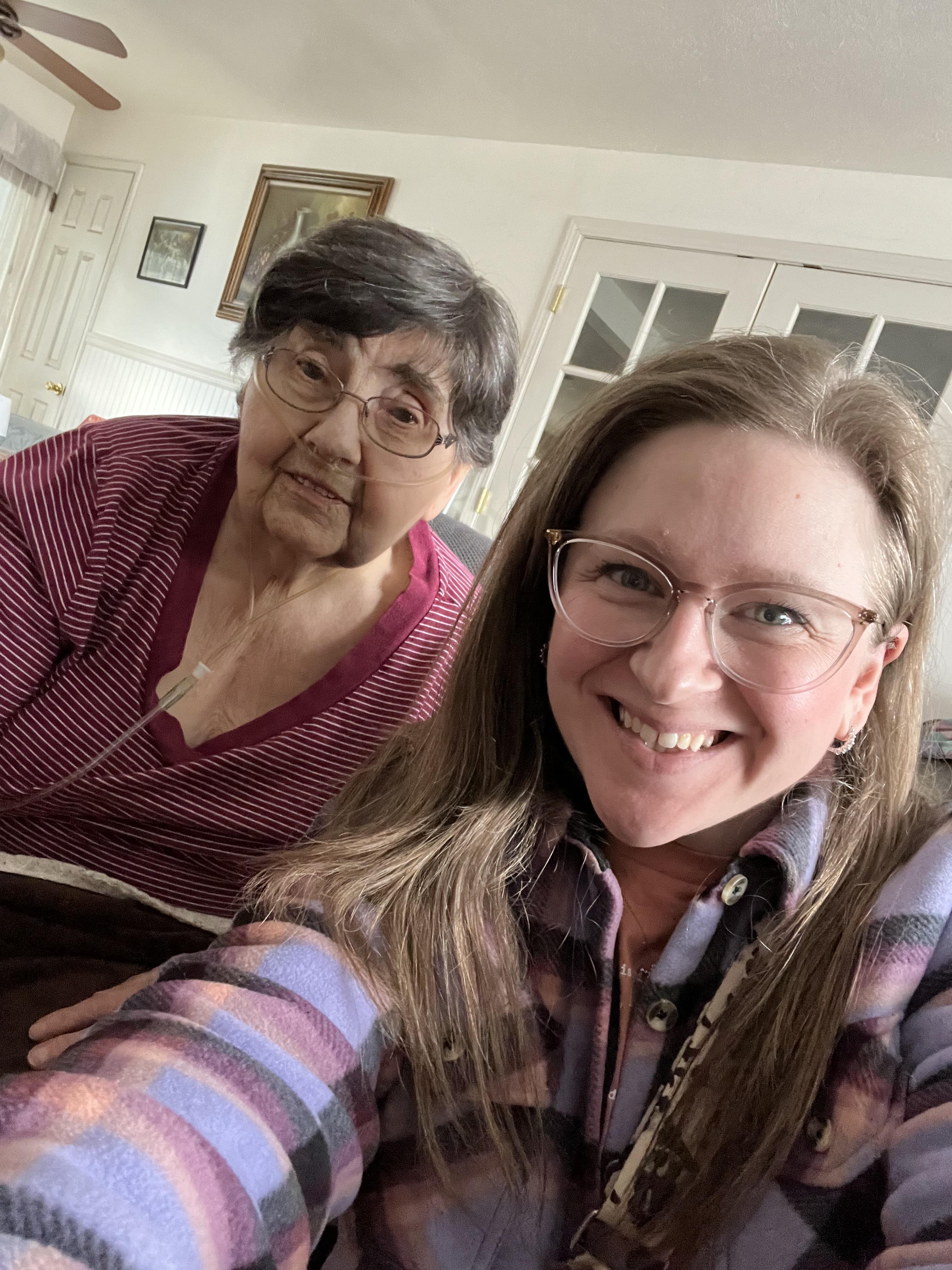 Two women share a warm moment indoors, bonding over their joyful smiles.