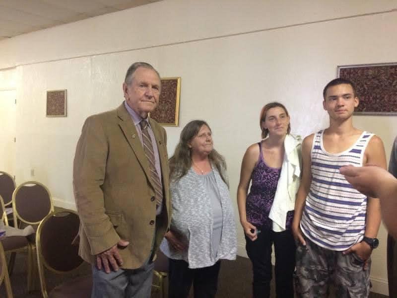 Four people pose happily in a casual setting, enjoying each other's company and conversation.